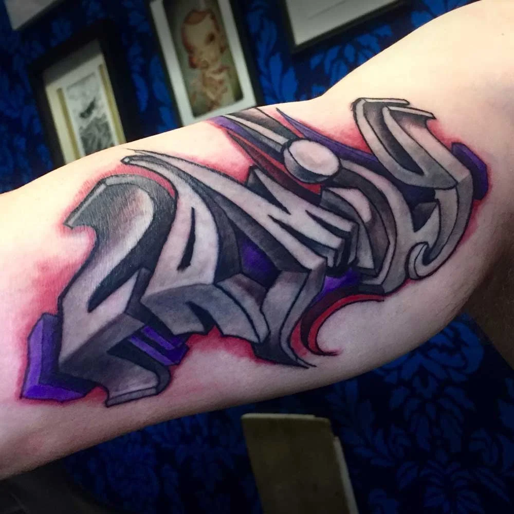 Colorful graffiti-style tattoo with the word "2024" on a person's arm, featuring bold, three-dimensional letters with black outlines and purple accents.