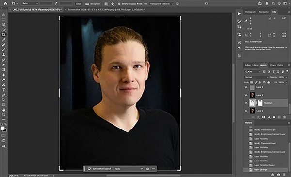 A person with long brown hair tied back, wearing a black shirt, looking at the camera in an indoor setting with a dark background, displayed on a computer screen editing software.