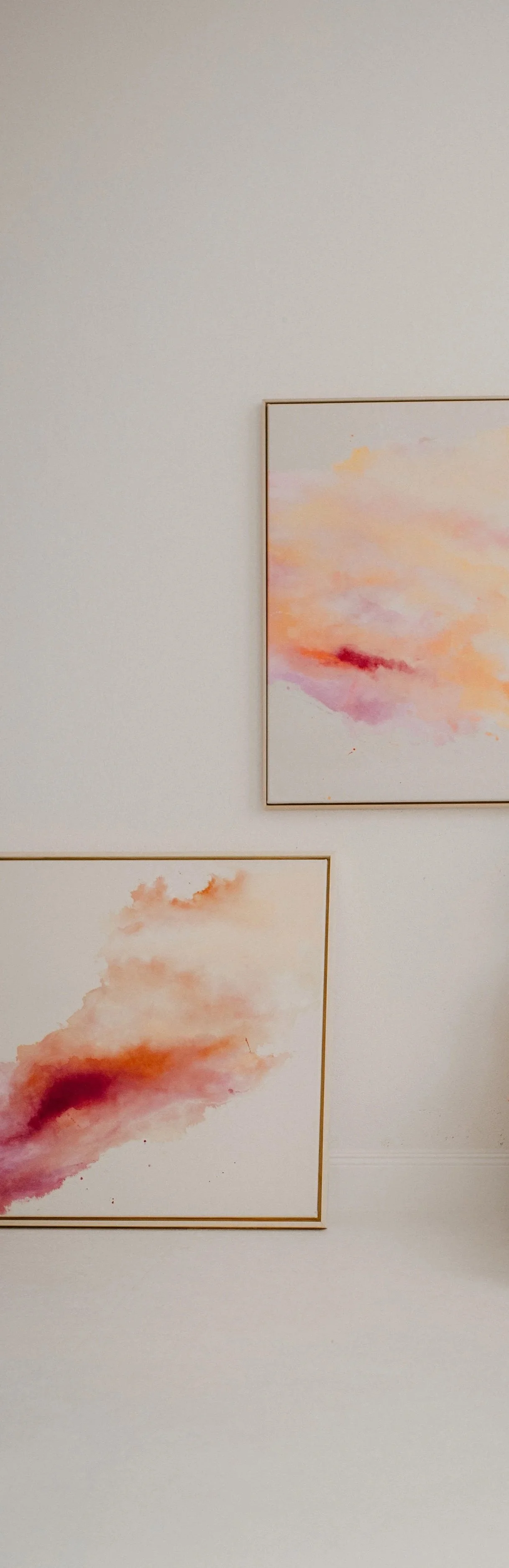 Zwei abstrakte Aquarellgemälde mit Himmelsszenen in Pastellfarben, gerahmt an einer weißen Wand in einem Kunstmuseum.