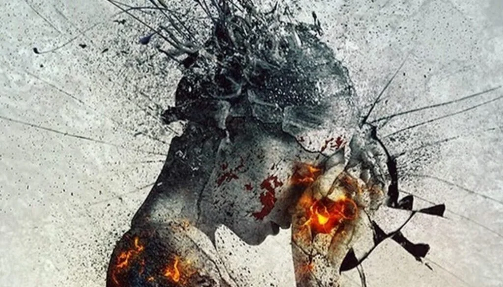 A surreal digital artwork of a person's profile with a shattered glass effect. The person's head appears to be exploding into paint splatters and light with elements resembling fire and an orange heart. The background is light gray with black and orange accents.
