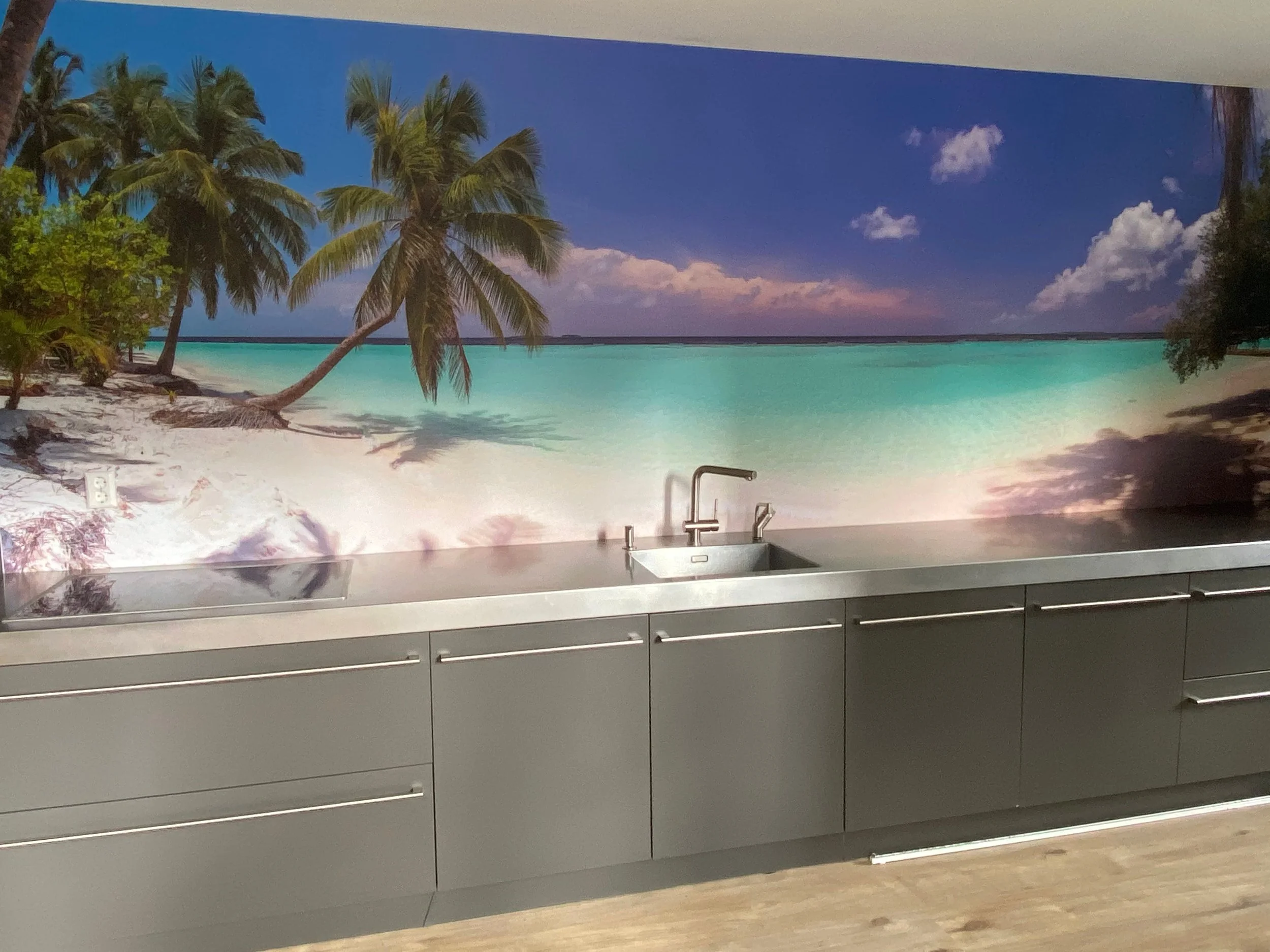Tropical beach wall mural wallpaper with palm trees and ocean installed above kitchen counter – Pop Papel panoramic coastal seamless wallcovering completed project