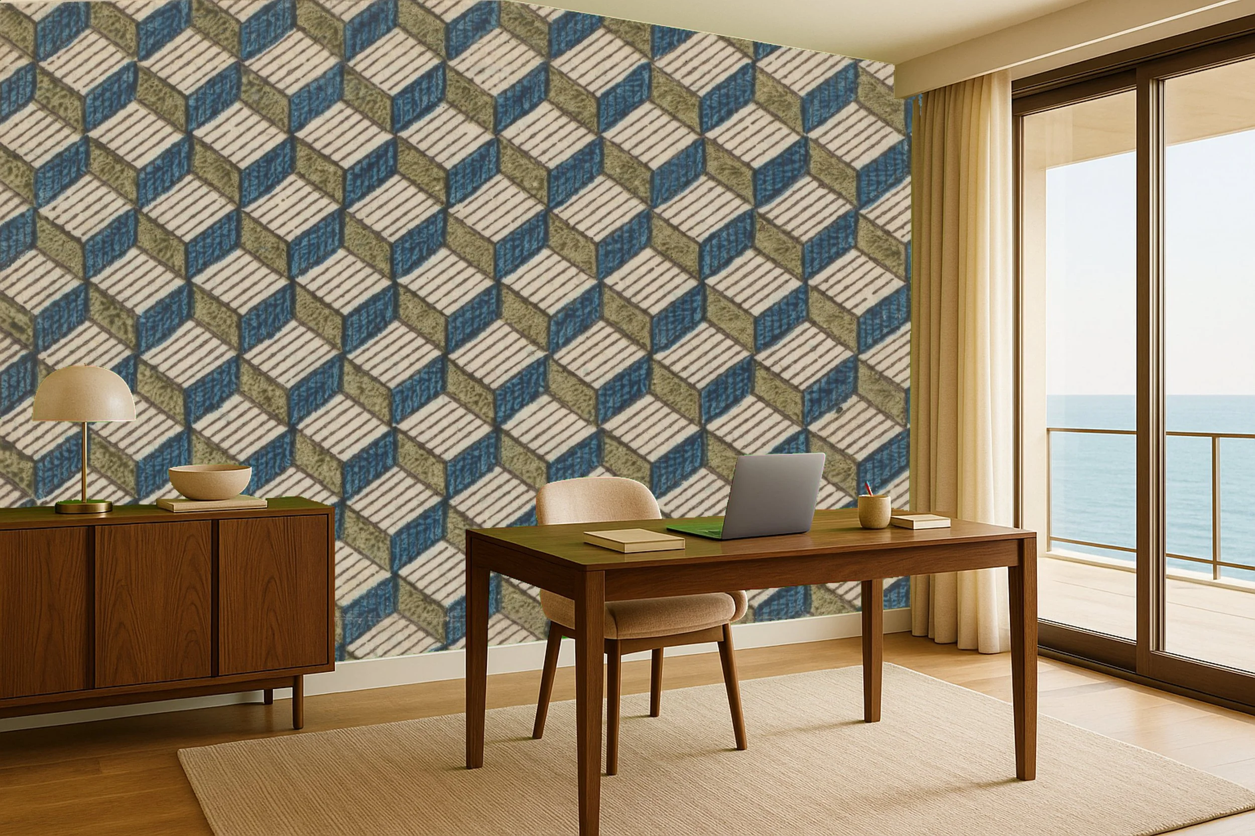 Modern office with wooden desk, beige chair, laptop, books, mug, and a sideboard with lamp and bowl, overlooking the ocean from a balcony with sliding glass doors.