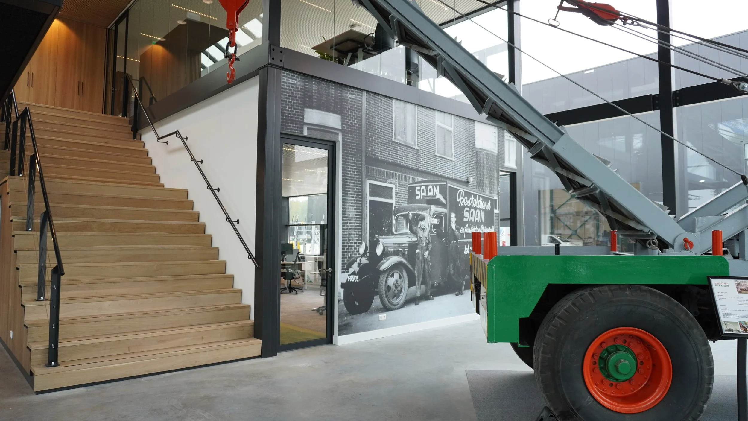 Industrial interior with large-scale city wall mural wallpaper along staircase – Pop Papel panoramic urban seamless wallcovering completed project