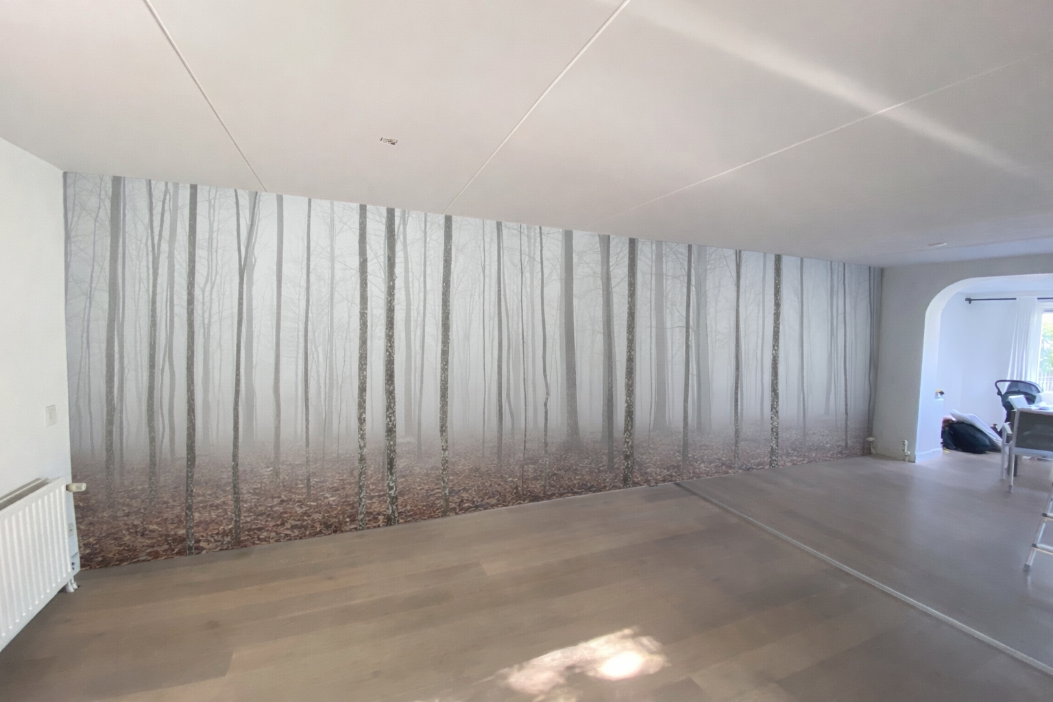 Minimalist forest wall mural wallpaper with soft vertical tree pattern installed in modern interior – Pop Papel seamless wallcovering completed project