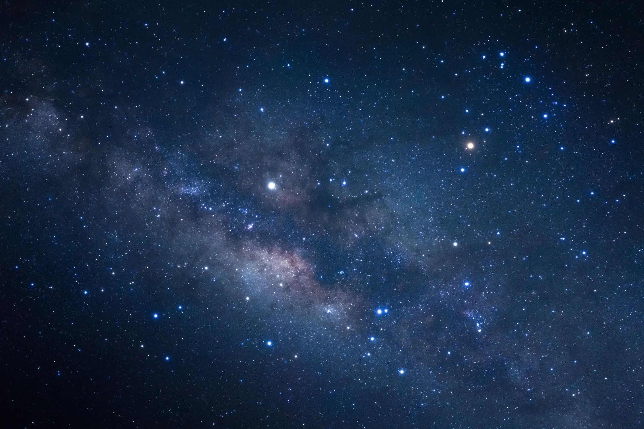 A view of the night sky filled with stars and a visible section of the Milky Way galaxy.