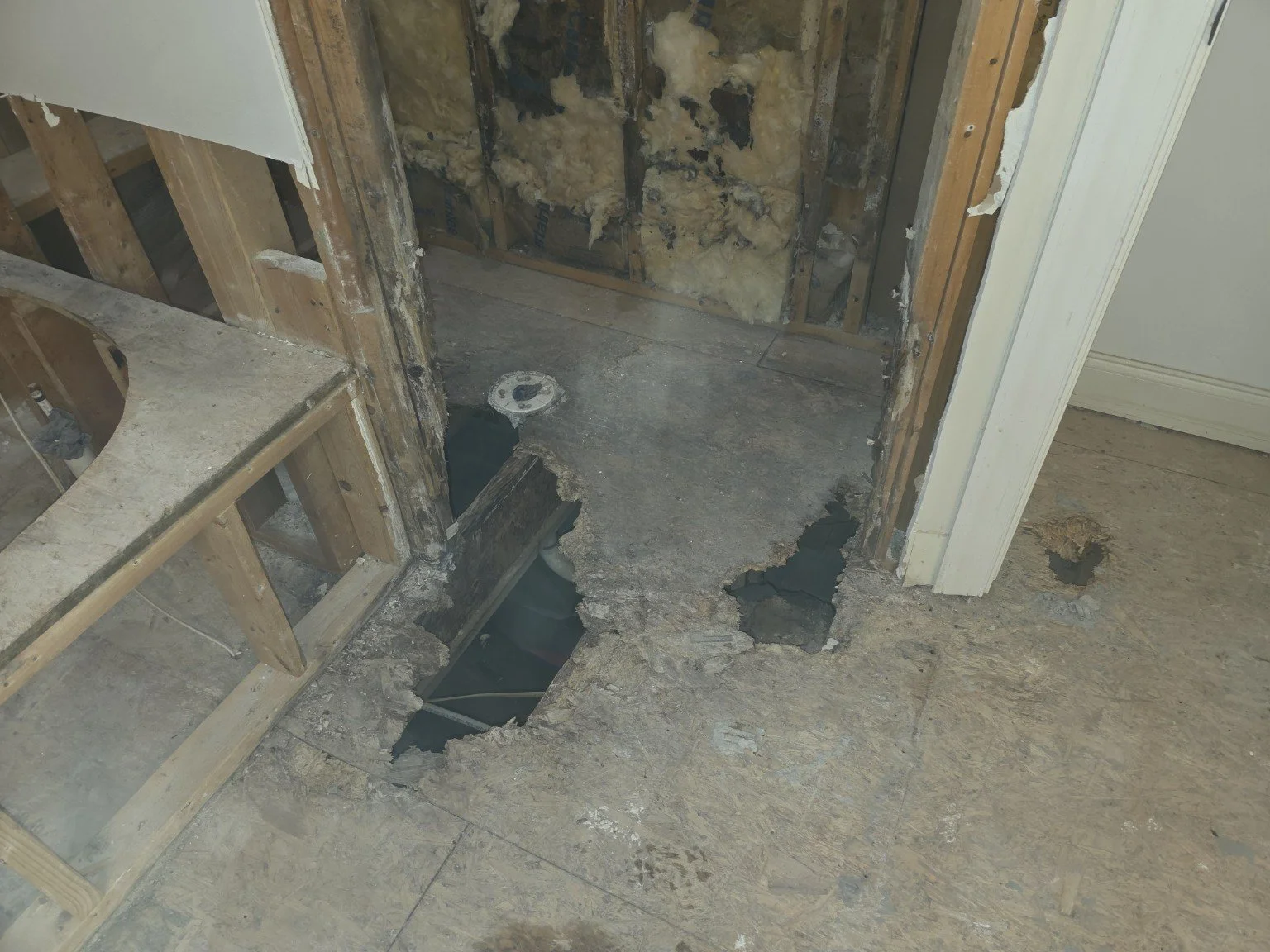 Water-damaged bathroom and shower subfloor before repair in Browns Summit, NC.
