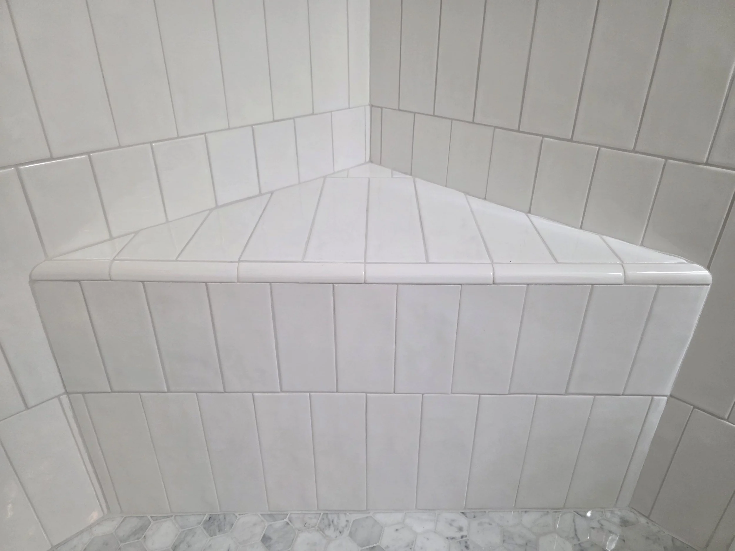 Custom tiled shower bench with vertical tile layout