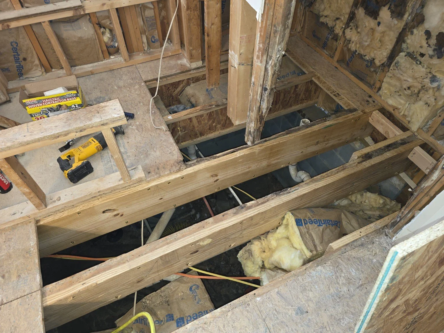 Bathroom floor joist repairs exposed after damaged subfloor removal in Browns Summit, NC.