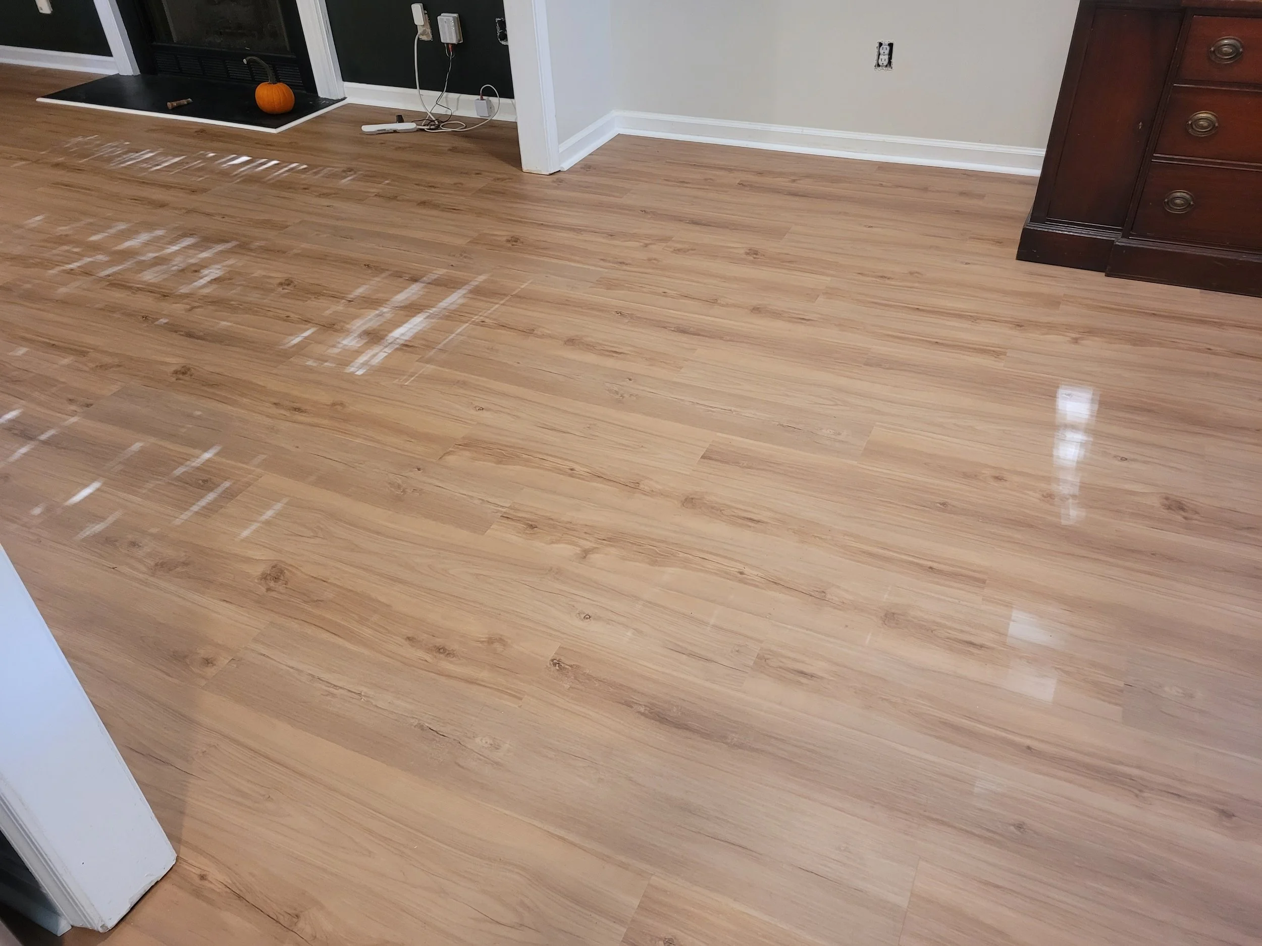 Newly installed laminate flooring in a living room completed by a residential flooring contractor serving Browns Summit and Greensboro, NC