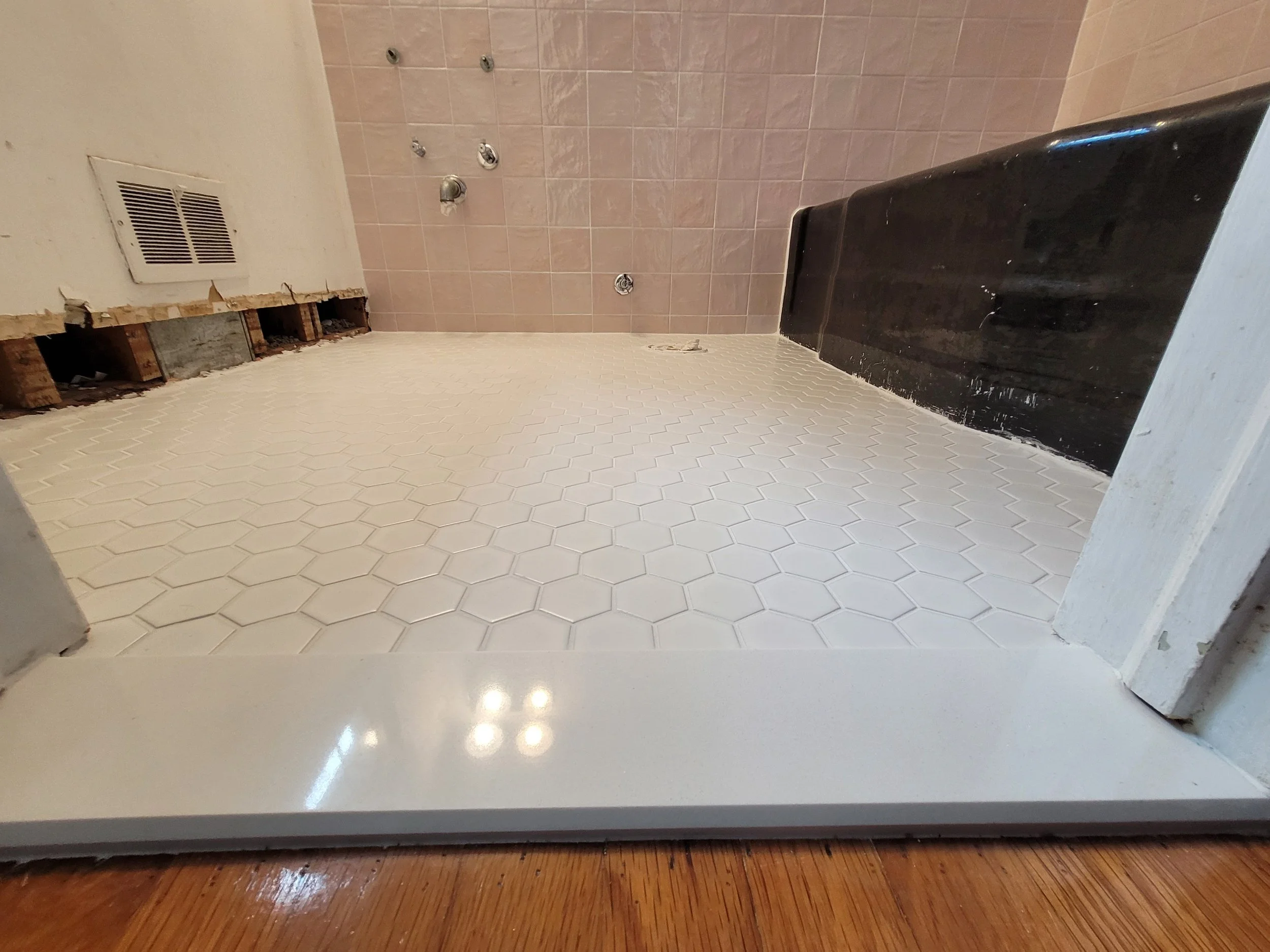 Bathroom remodel in progress featuring ceramic and porcelain tile flooring with shower valve and fixture plumbing work completed by a local contractor serving Greensboro and Browns Summit, NC