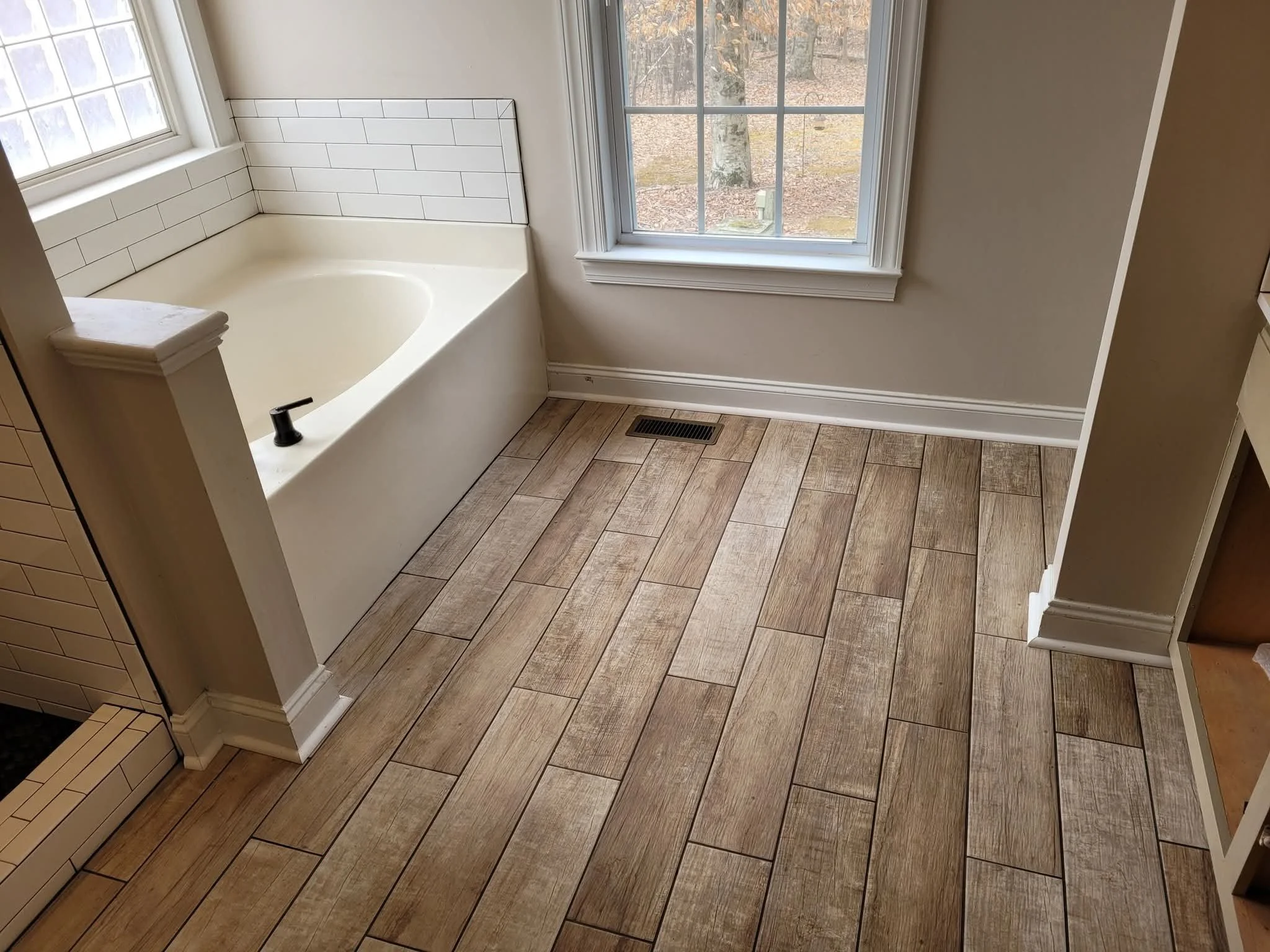 Bathroom remodel with wood-look tile flooring and tiled tub surround in Greensboro NC