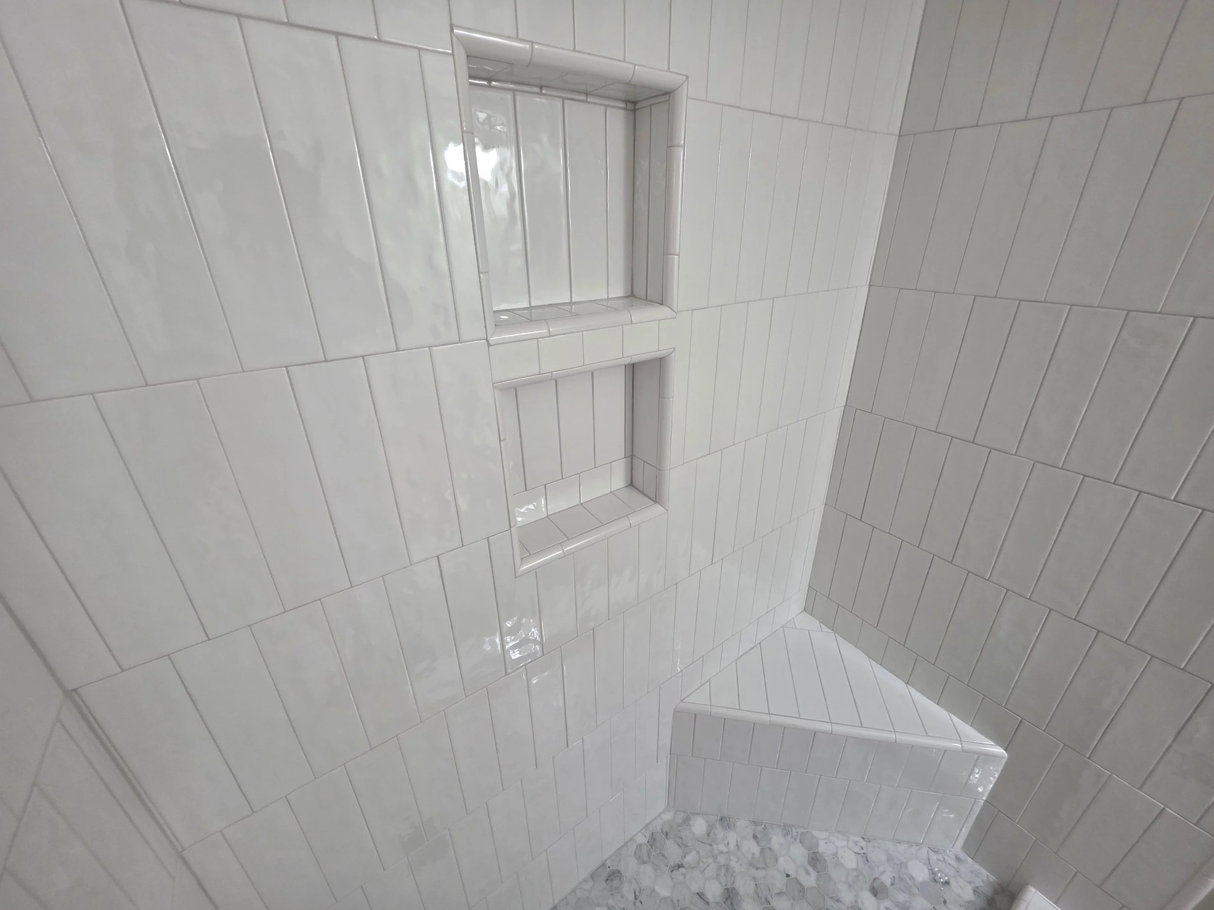 Custom tile shower with built-in bench and stacked niches in Greensboro, NC