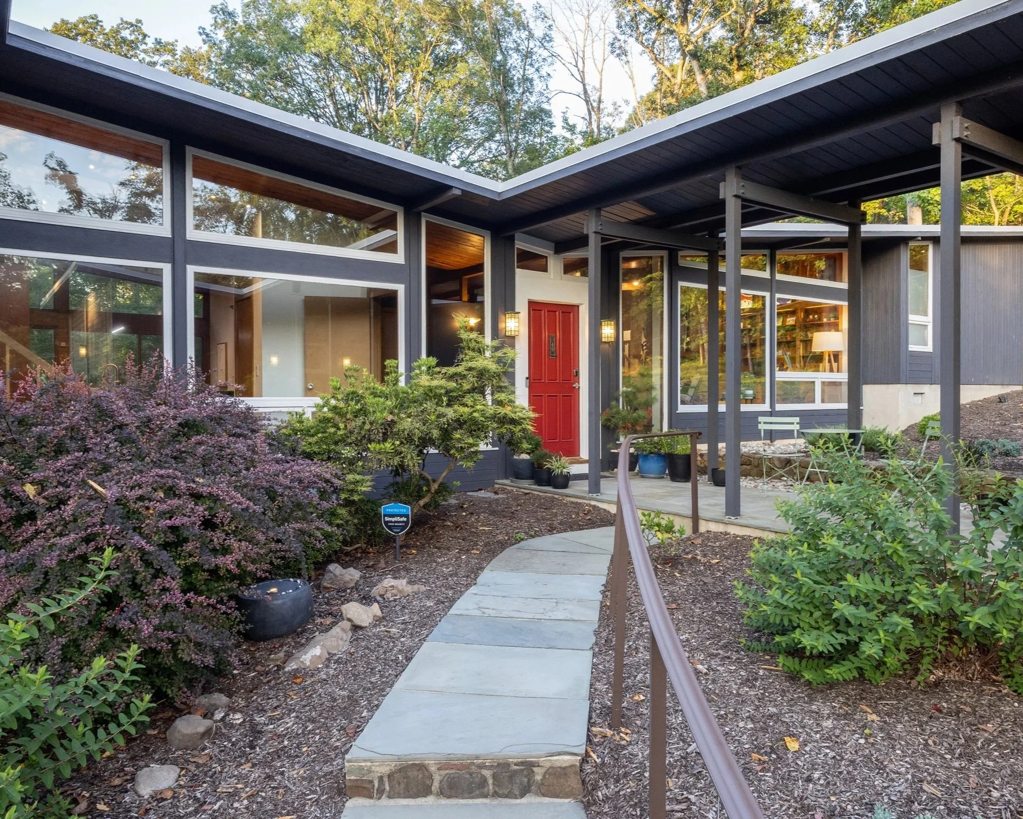 Mid-century modern home in Watchung, NJ with iconic butterfly roof, glass facade, naturalistic landscaping, and film-ready curb appeal.