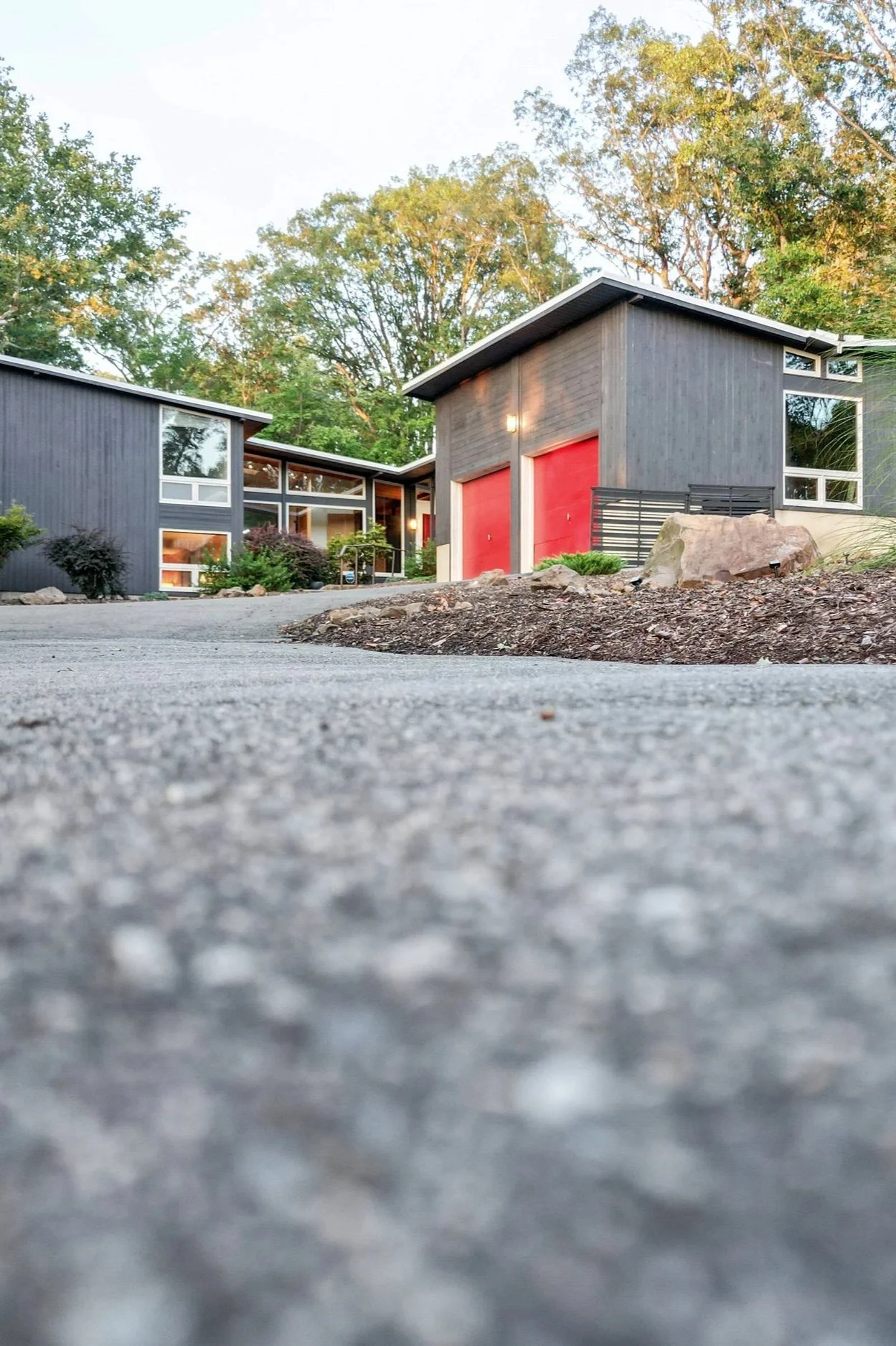 Mid-century modern filming location in New Jersey with iconic butterfly roof, glass facade, naturalistic landscaping, and wooded surroundings.