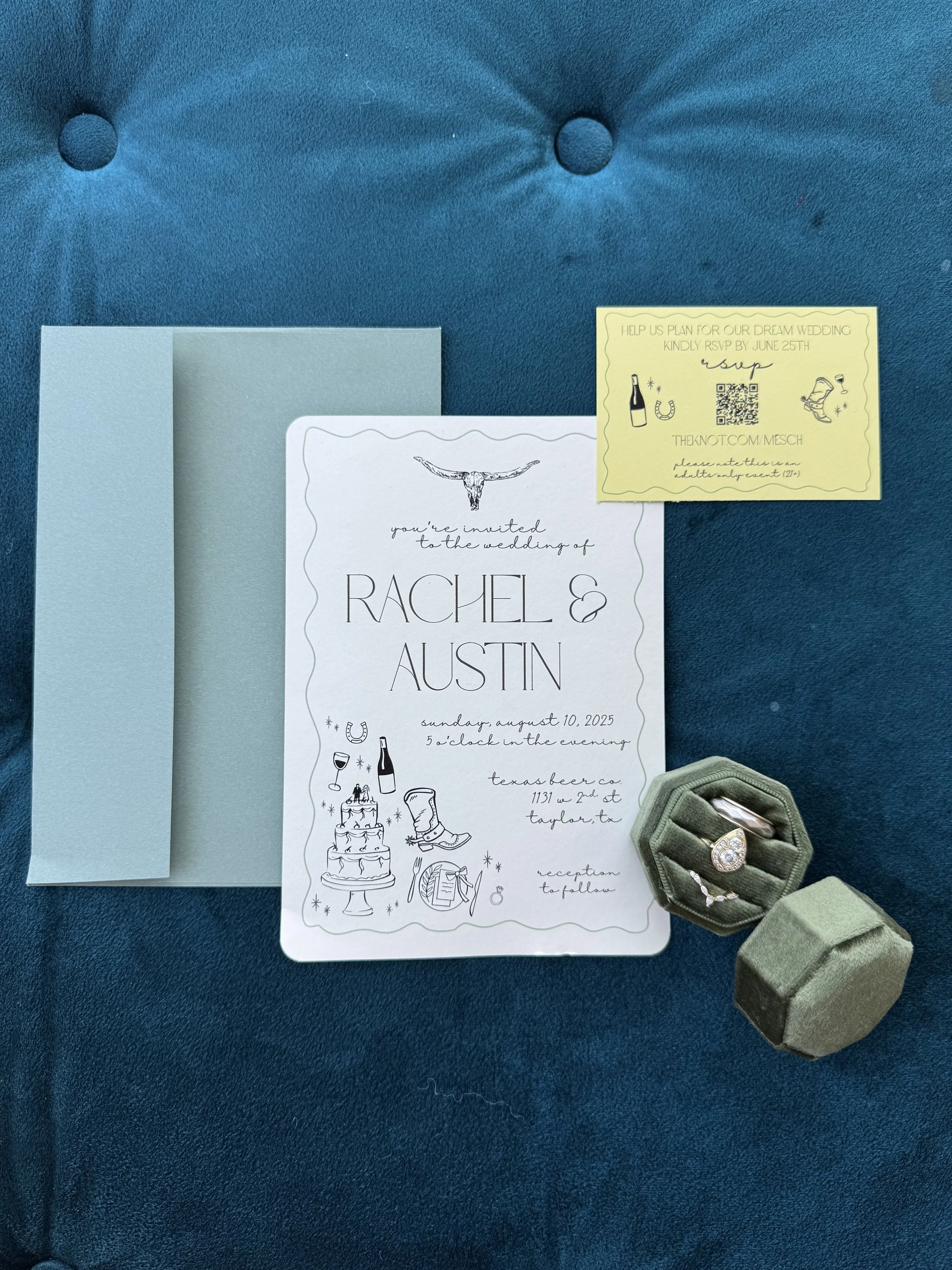 Wedding invitation and details for Rachel and Austin, including a small box of jewelry, on a blue surface
