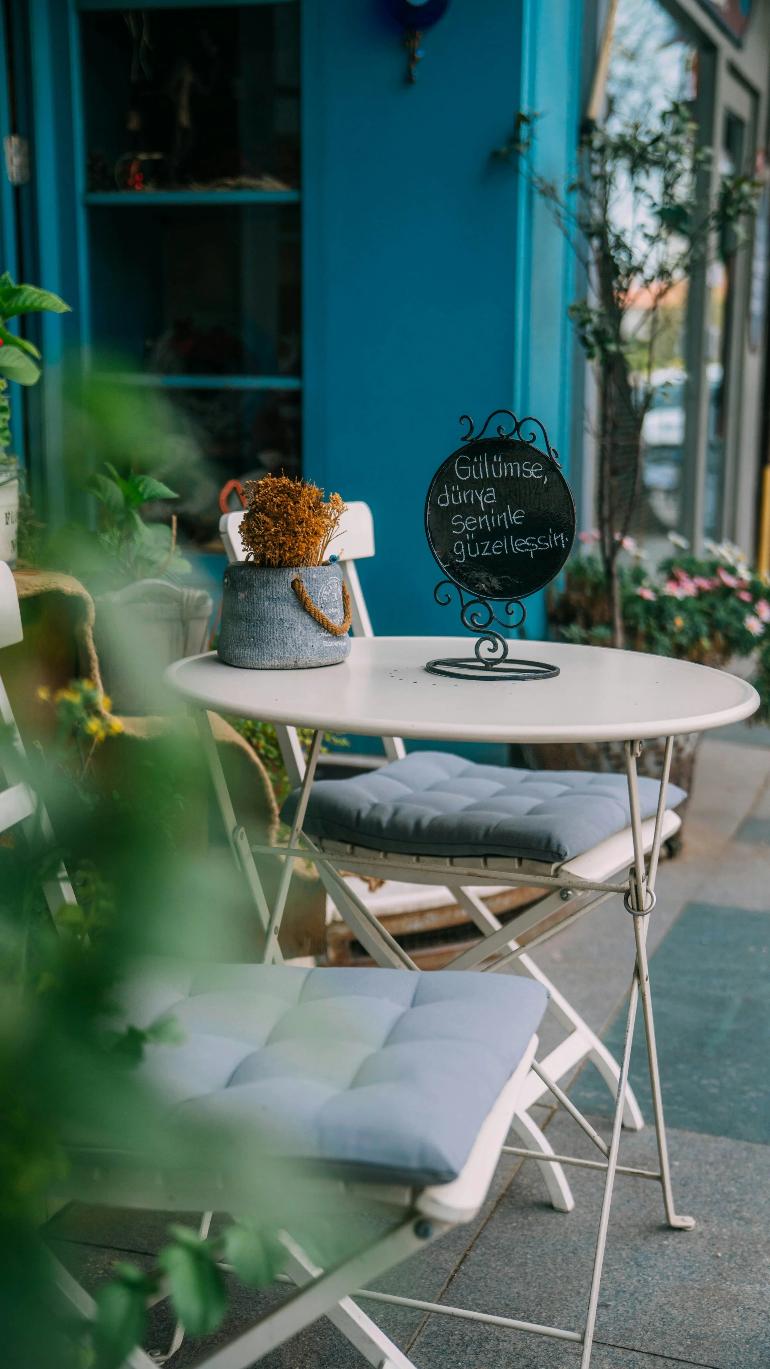 Two empty chairs at an outdoor cafe table in Lisbon, representing the everyday lifestyle available through the Portugal D8 Digital Nomad Visa