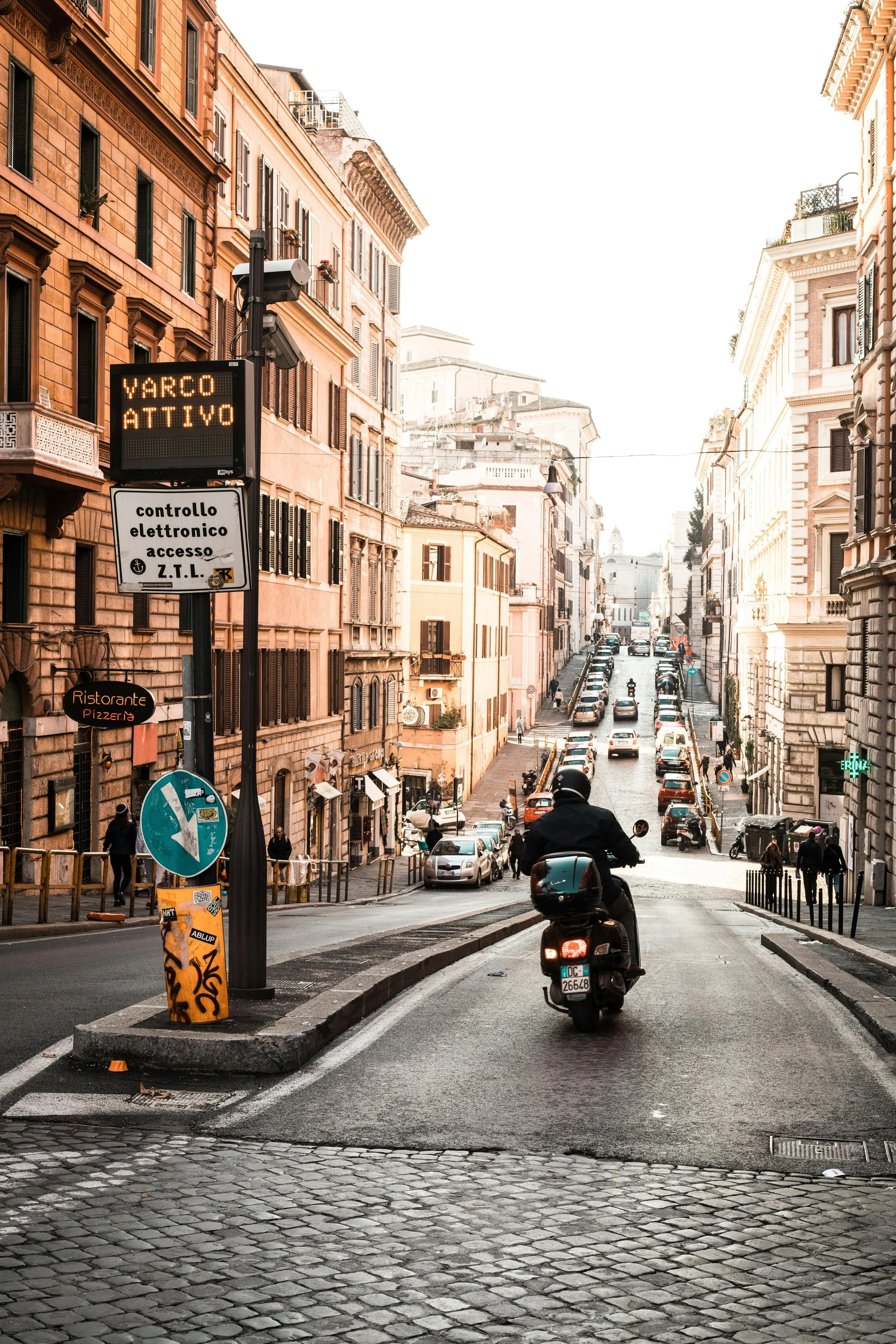 Italy street scene with parked cars and a man on a scooter, everyday life in Italy for Digital Nomad Visa holders