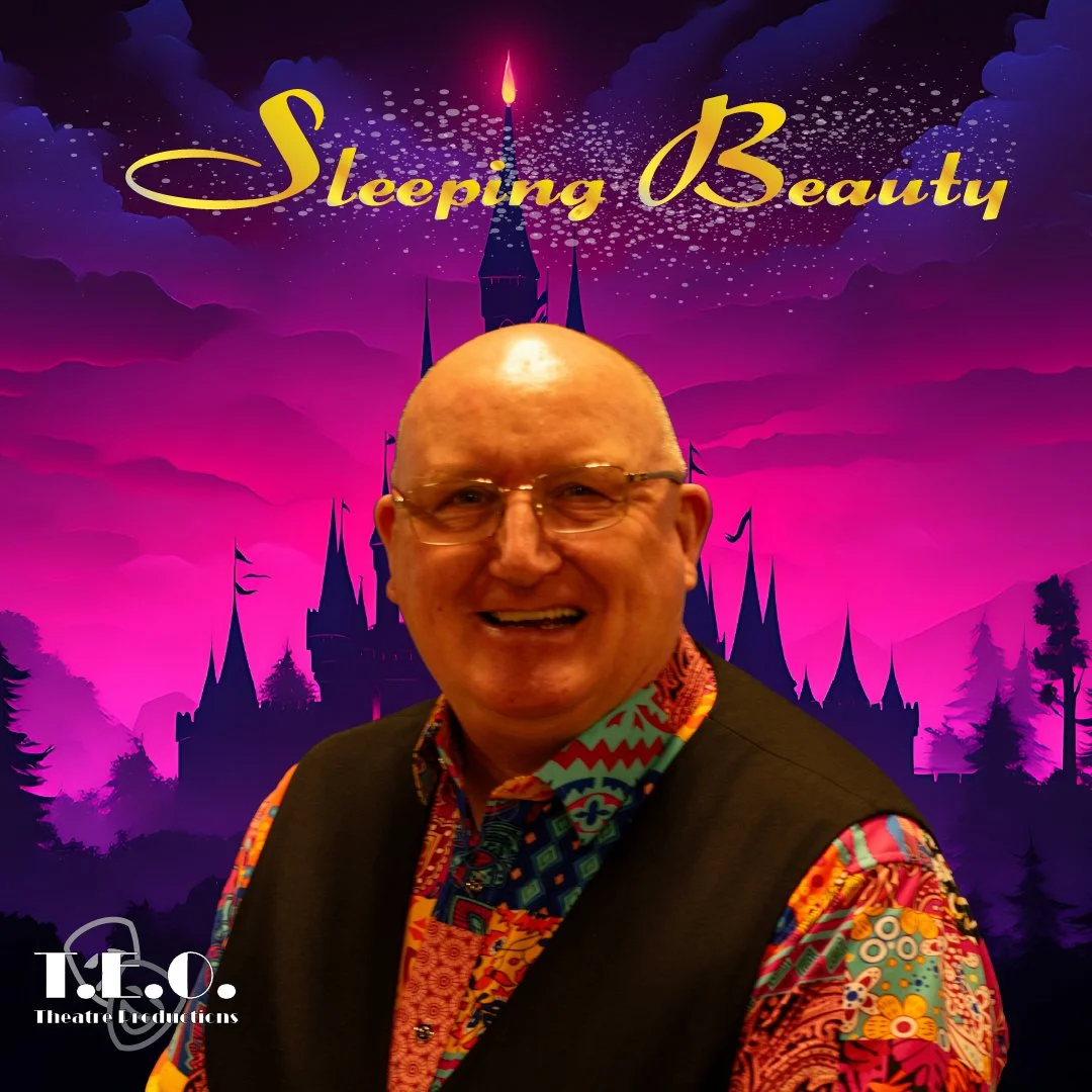 A smiling man with glasses, wearing a colorful patterned shirt and a black vest, standing in front of a fantasy castle with purple and pink sky background. The text 'Sleeping Beauty' is at the top, and the T.E.O. Theatre Productions logo is at the bo