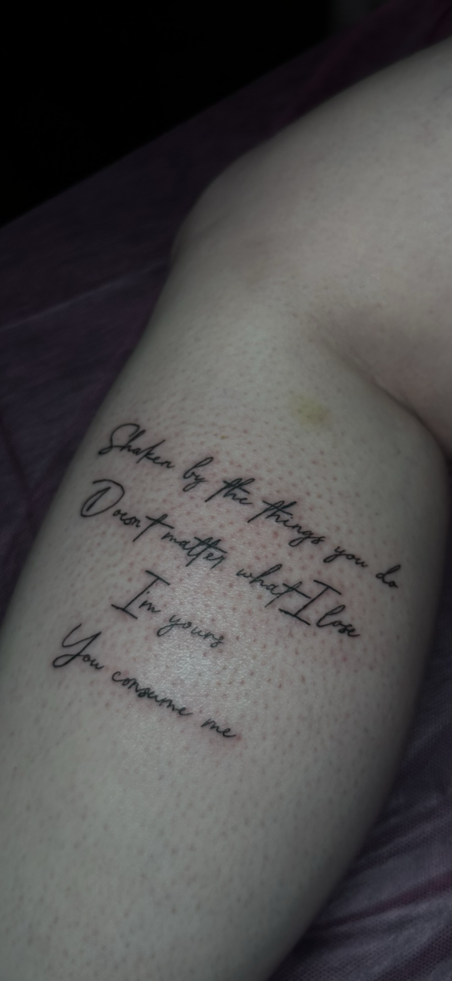 Tattooed arm with the quote: "Shaken by the things you do, Don't matter what I lose, In your arms you consume me."