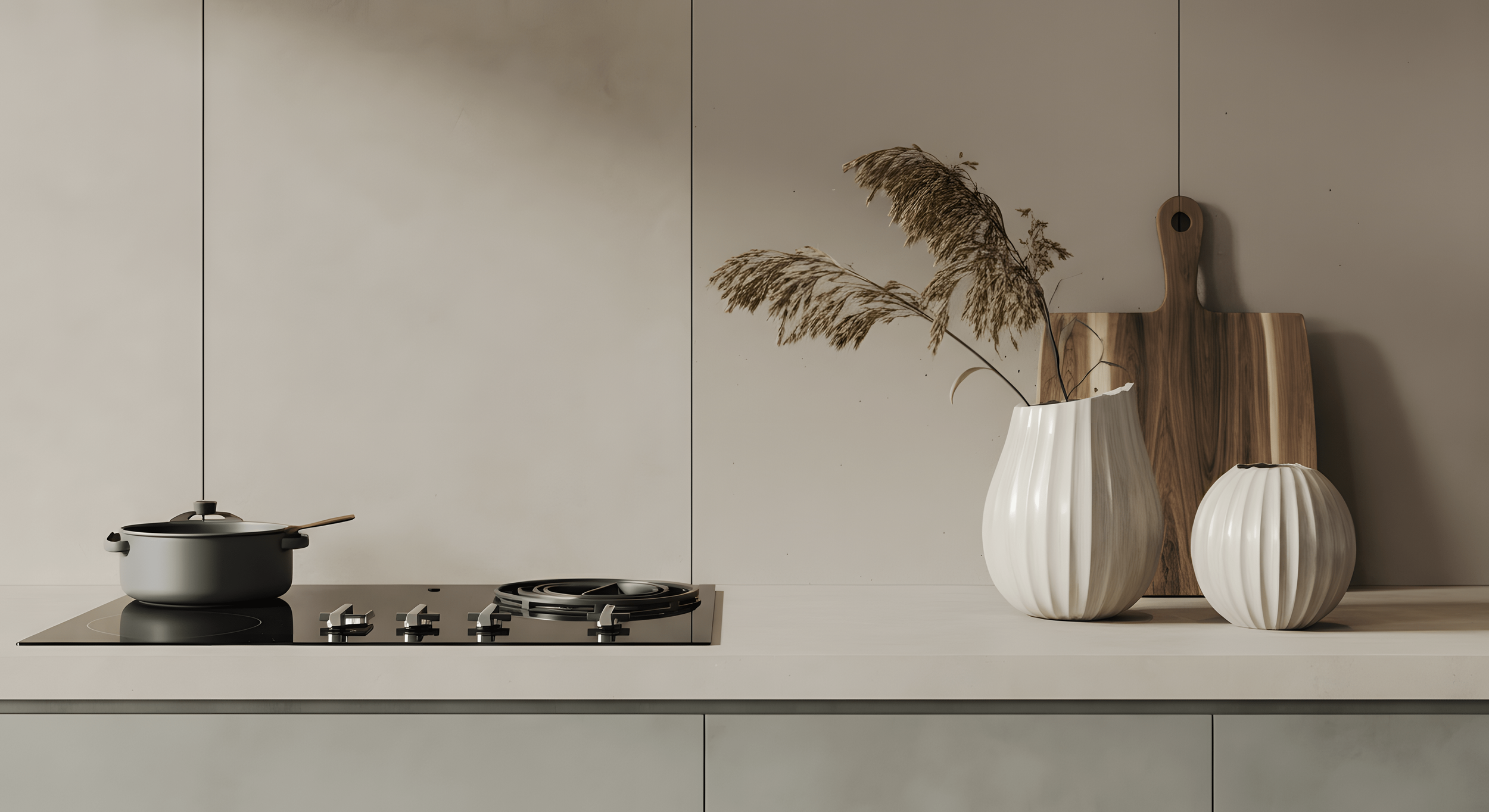 A modern kitchen countertop with a black pot on an electric stove, two white vases with dried plants, and wooden cutting boards in the background.
