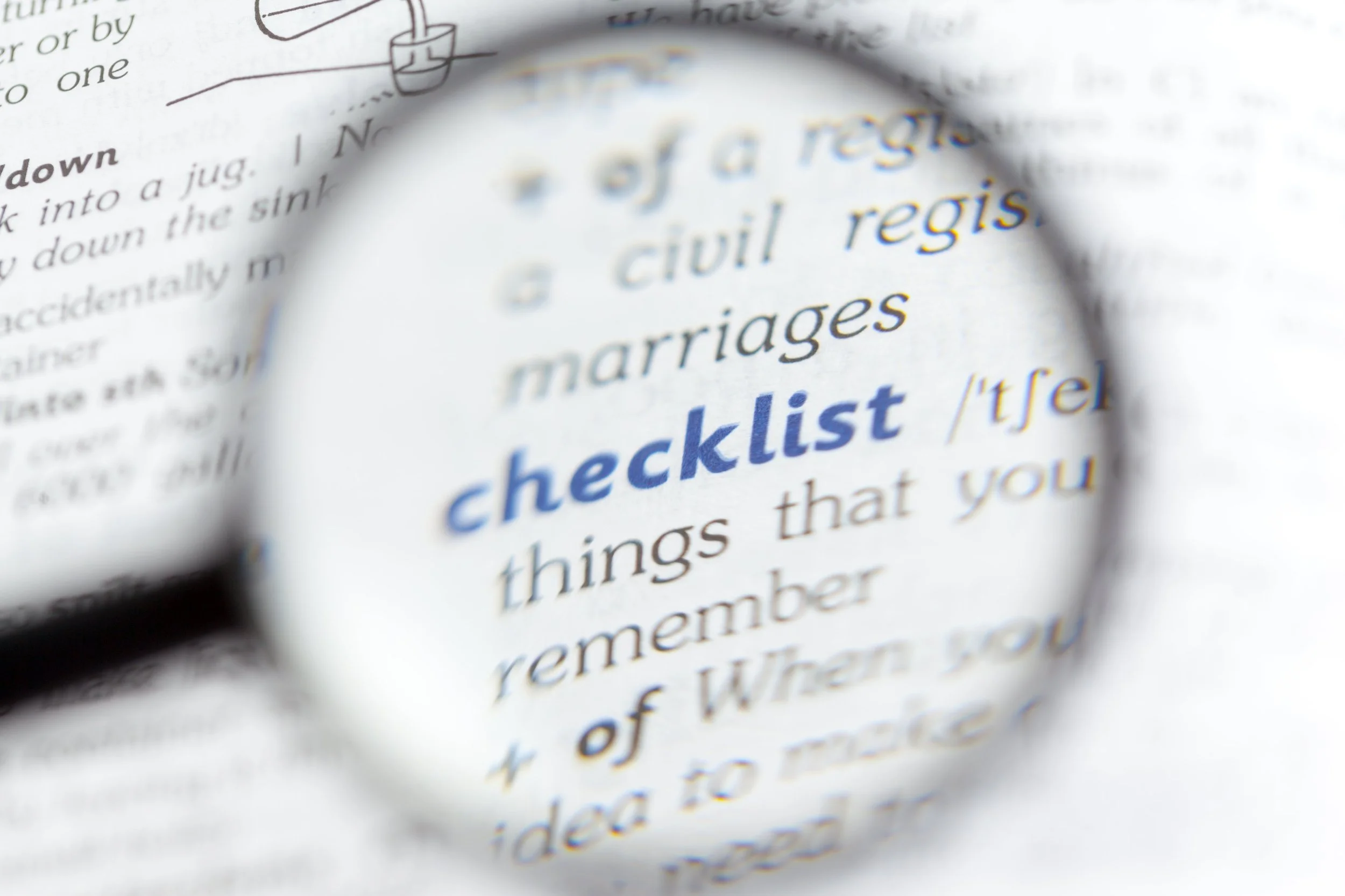 A page from a book using a magnifying glass to enlarge the word "checklist" and nearby text.
