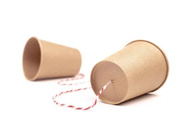 Two empty paper cups connected with red and white striped string.