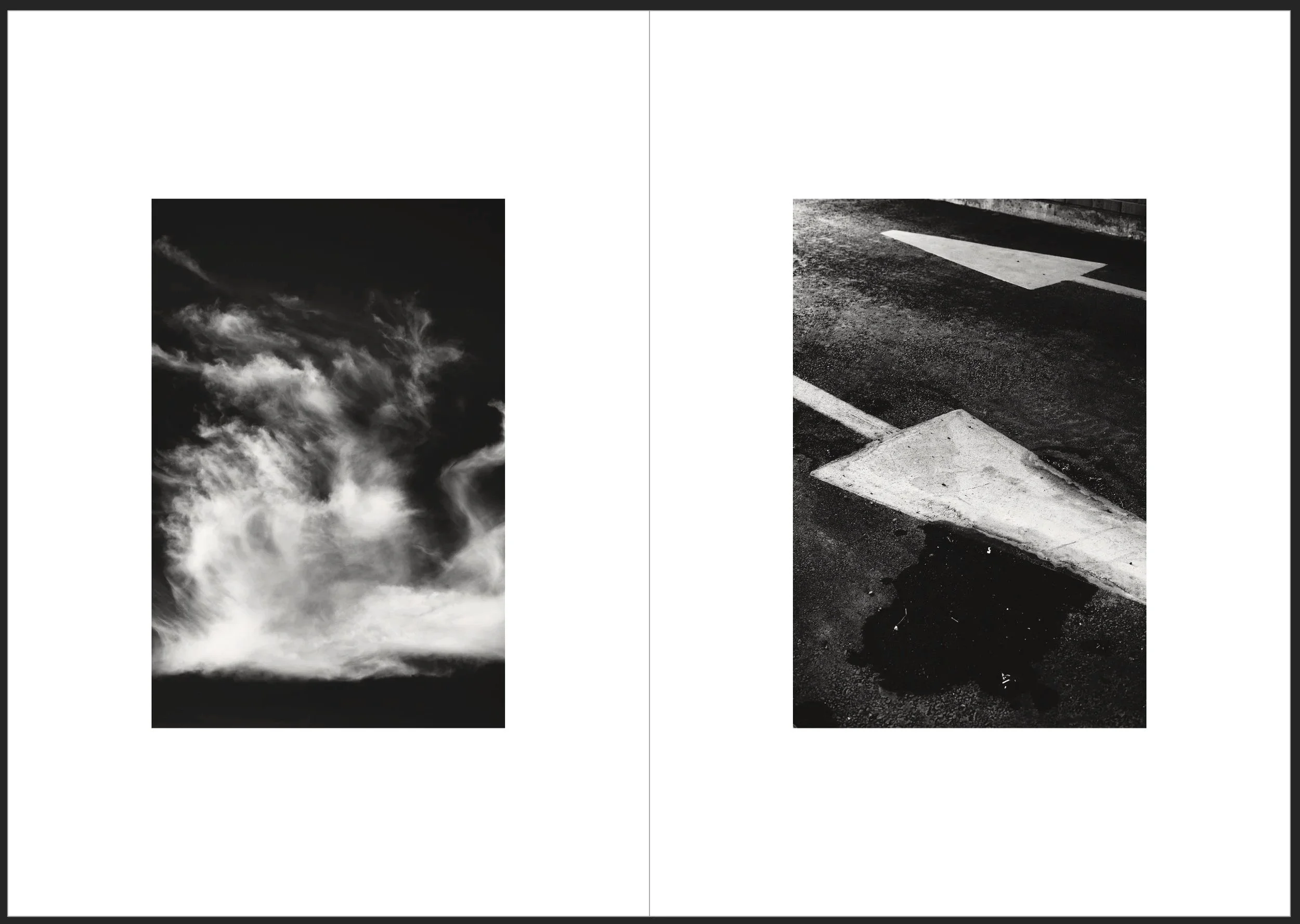 Black and white photo of clouds in the sky on the left side and a close-up of a curb with painted street markings on the right side.