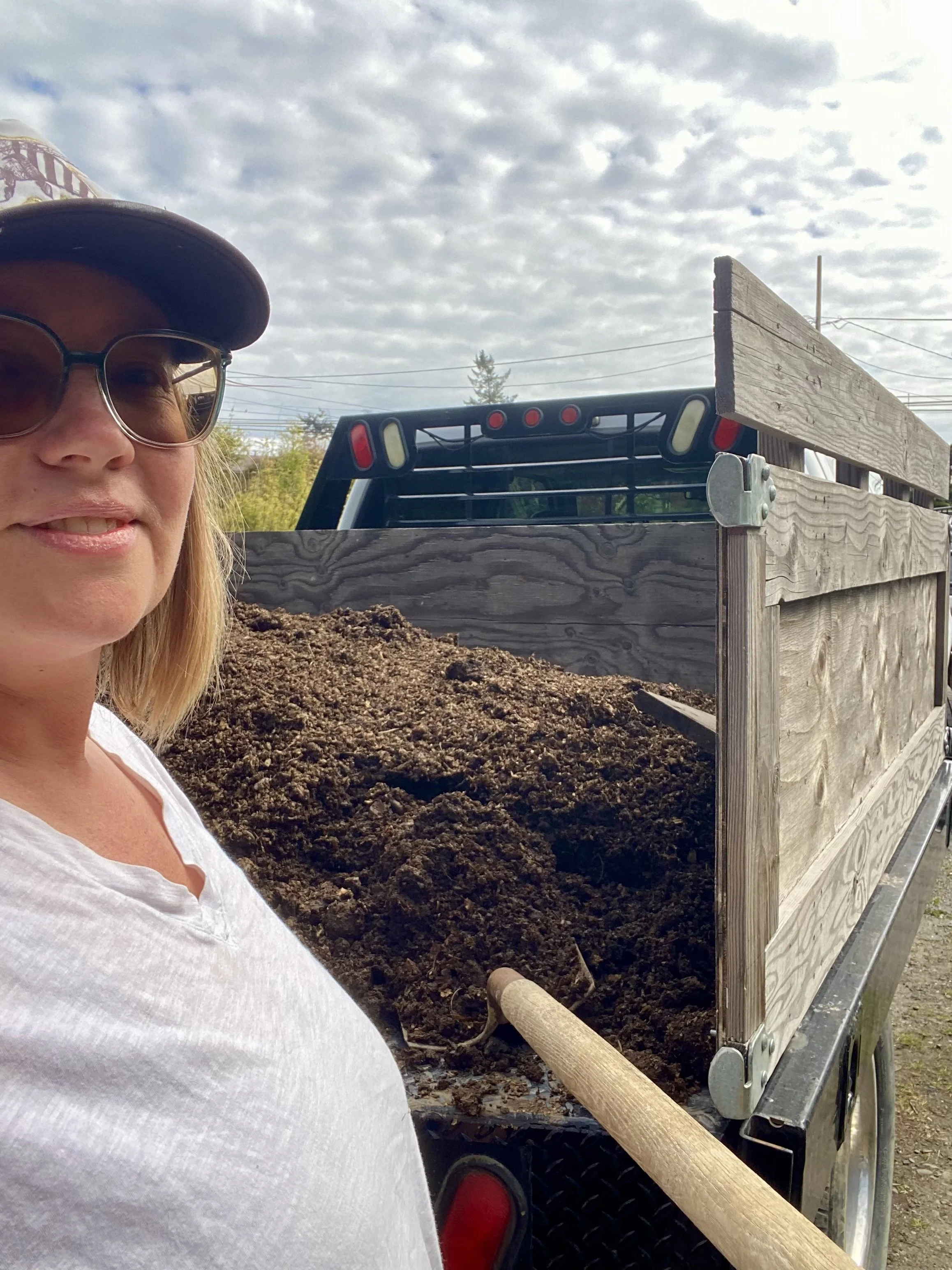 Humboldt Permaculture Guild board member Sara Marie poses in front of a truck of plant gold (poo)