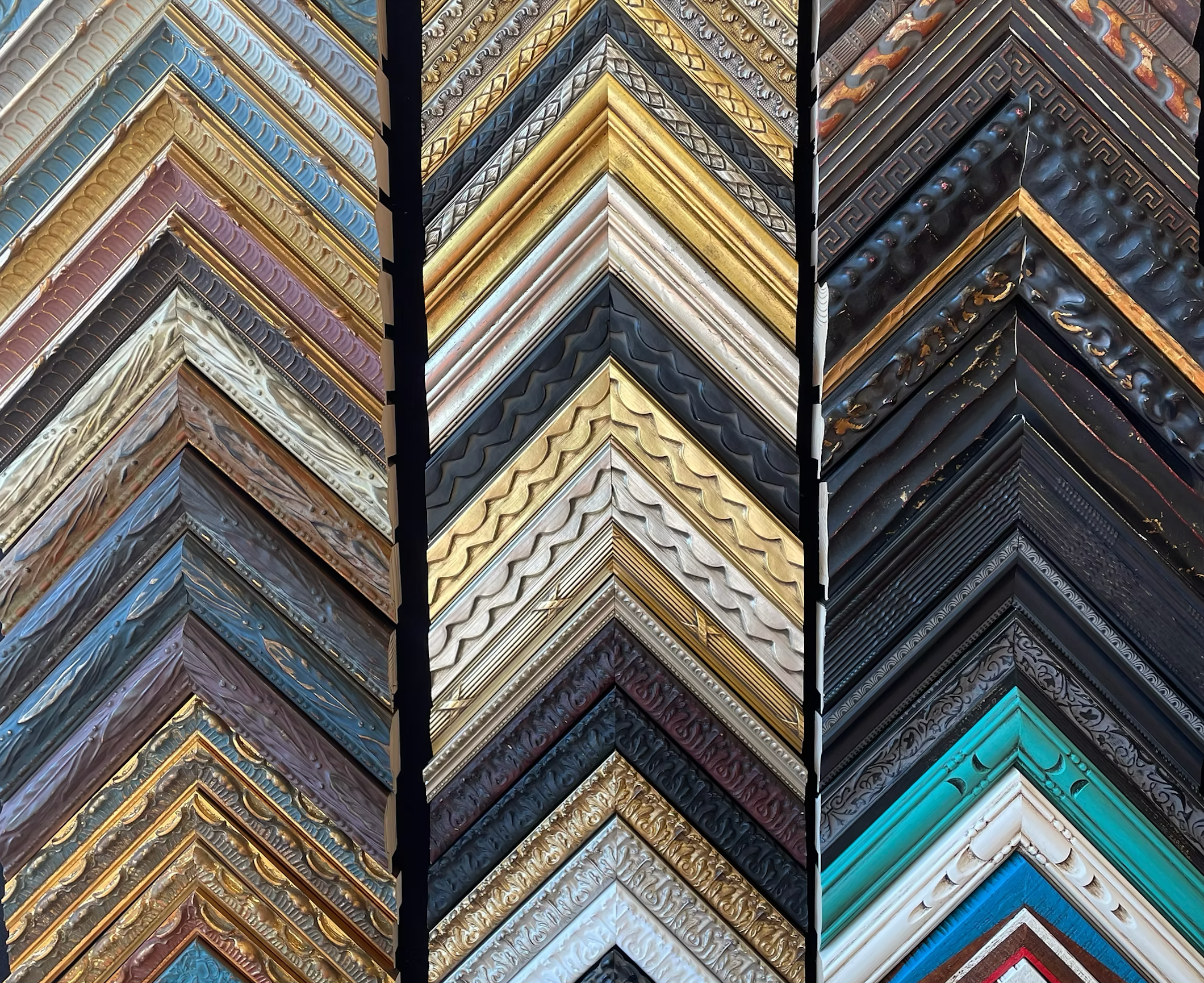 A variety of picture frames arranged in columns, showcasing different styles, colors, and textures.