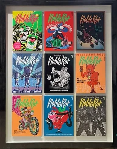 A display case with nine colorful comic book covers, featuring various characters and titles.
