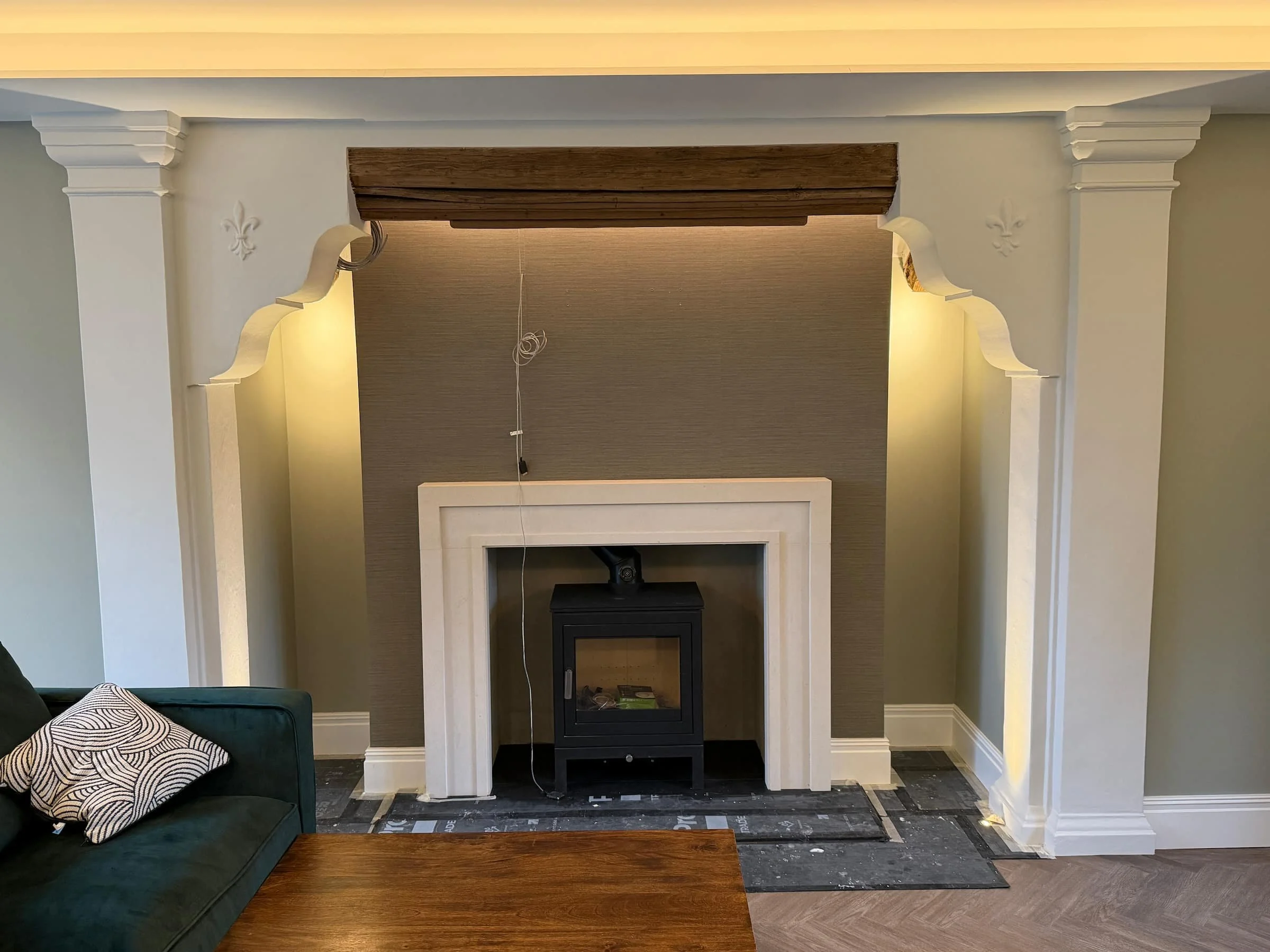 Grasscloth wallpaper installation around a restored period fireplace in Harpenden, Hertfordshire