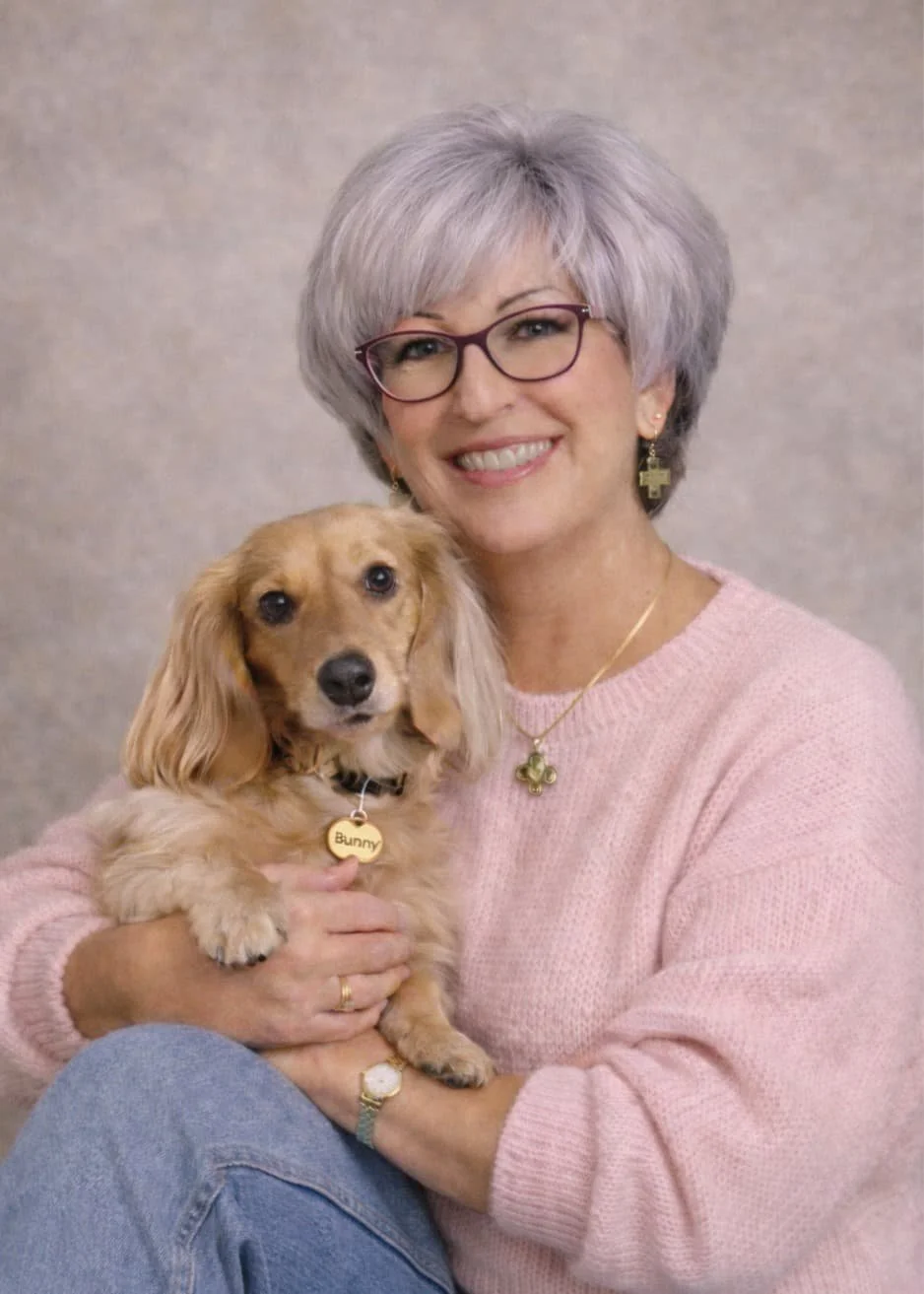 Portrait of Joy, founder of Scatter Joyfulness Greetings, holding her dachshund Bunny, reflecting the heart behind her handmade micro art greeting card gifts.