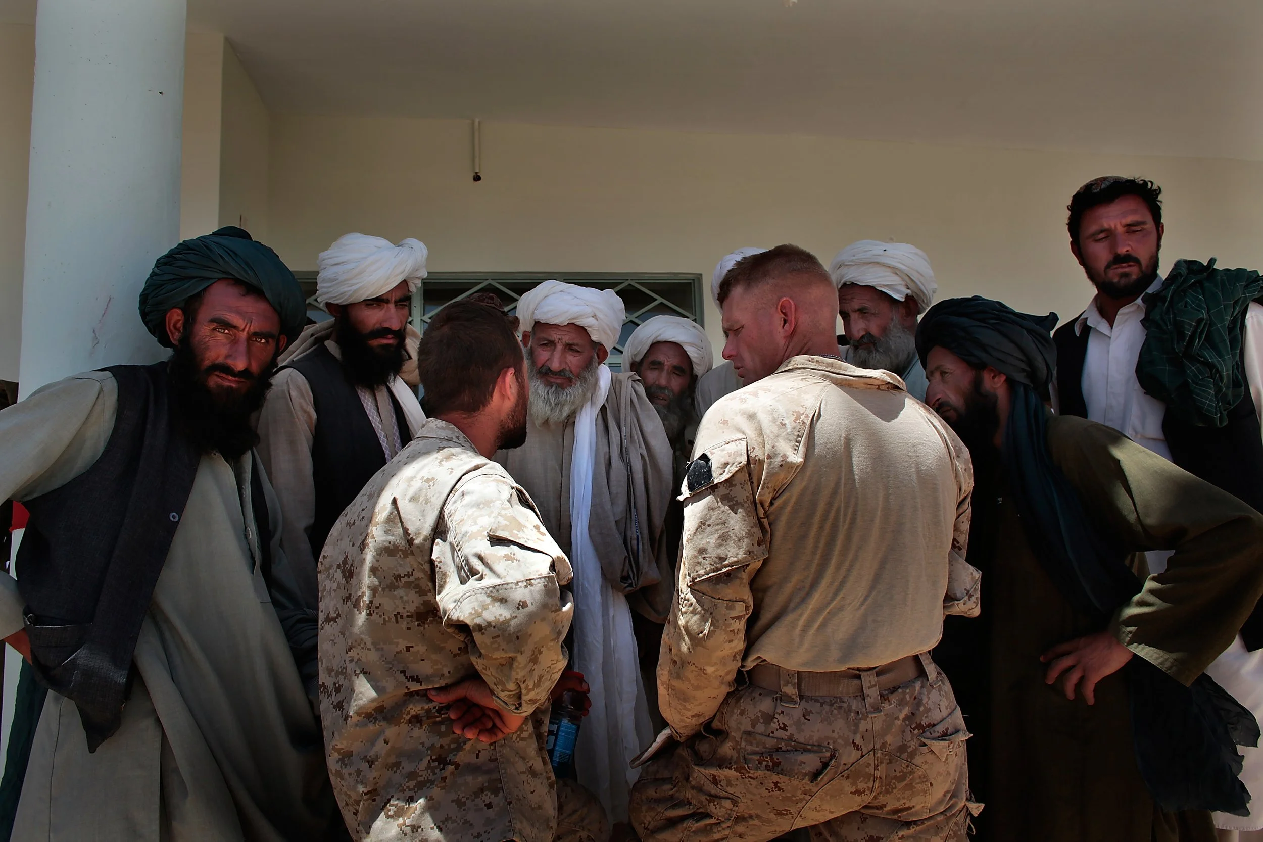 Marine officer and a translator talk to local leaders after shura – held to discuss community concerns in Marjah, Afghanistan.