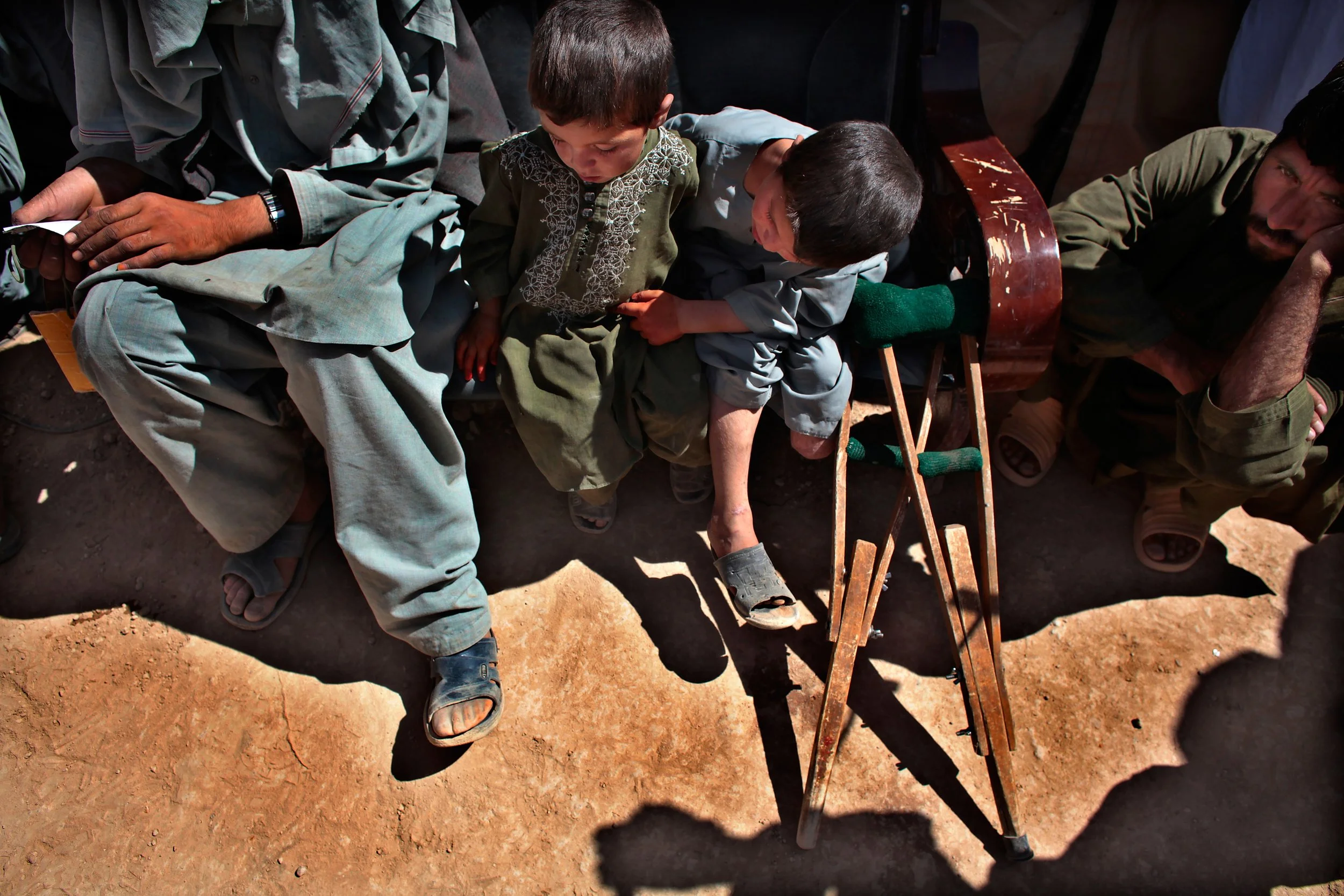 In a country littered with IEDs, missing limbs are heartbreakingly common. At a shura in southern Afghanistan, 7-year-old Najibullah — who lost his leg in an explosion — and his surviving brother study a prosthetic foot worn by another attendee. A qu