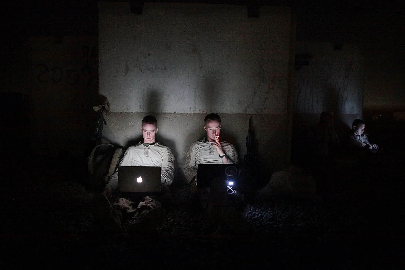 Two US Marines find a Wi-Fi hot spot under a blast wall at Camp Dwyer in southern Afghanistan. Temperatures can reach 120 degrees at the base. Coupled with a punishing wind and swirling dust, outside conditions are almost unbearable during the day.