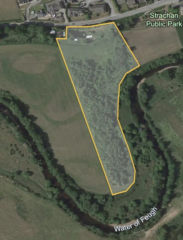 Aerial view of a Feughside Community Garden outlined in yellow, located near Strachan Public Park and Water of Feugh, featuring trees, grassy fields, a river, and some structures.