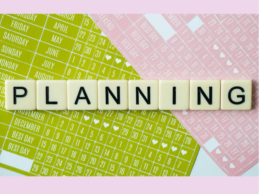 Scrabble tiles spelling 'PLANNING' placed on colorful calendars with dates and heart icons.