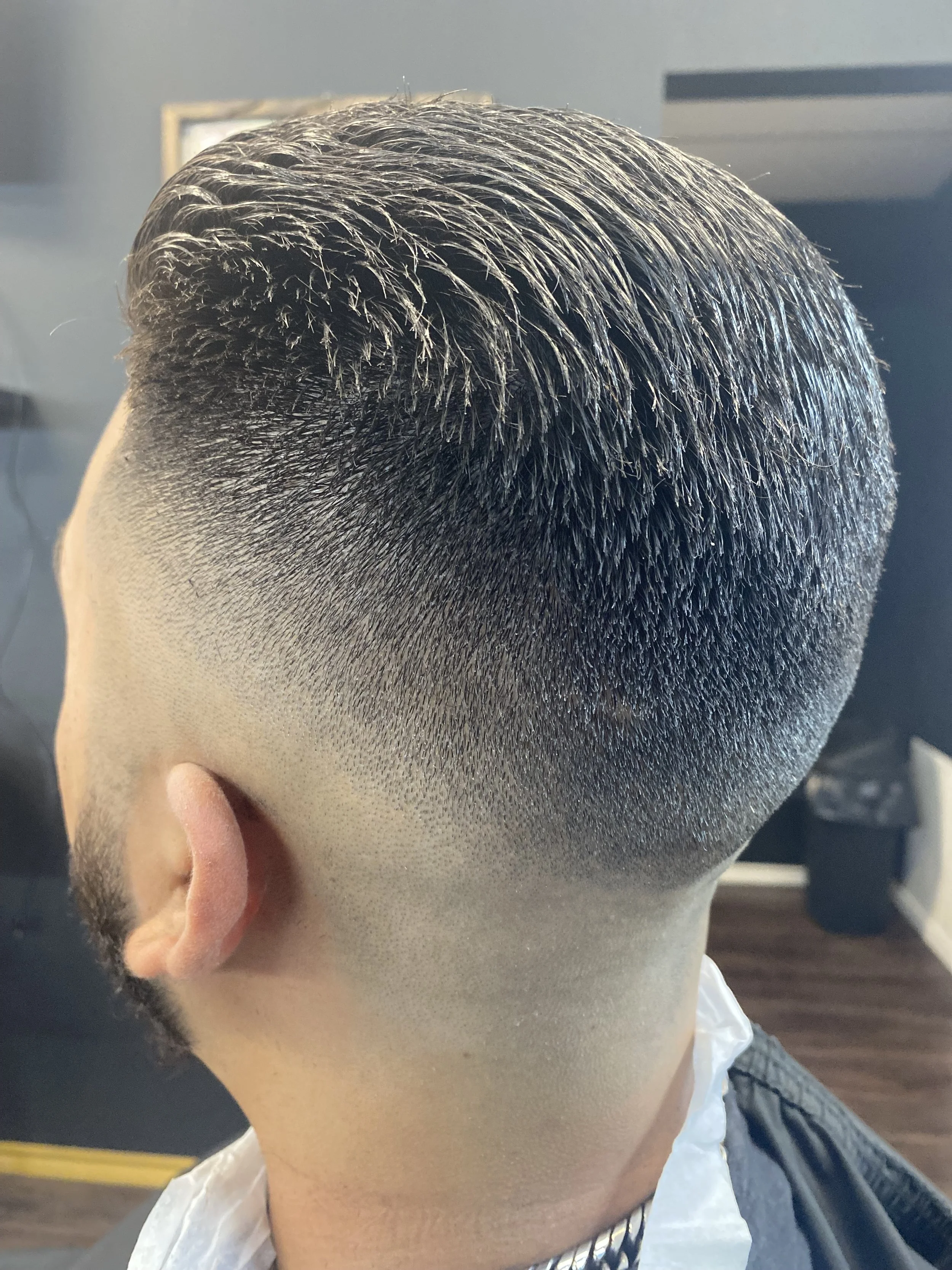 Close-up view of a man's fresh, modern haircut featuring a fade with textured top hair style.