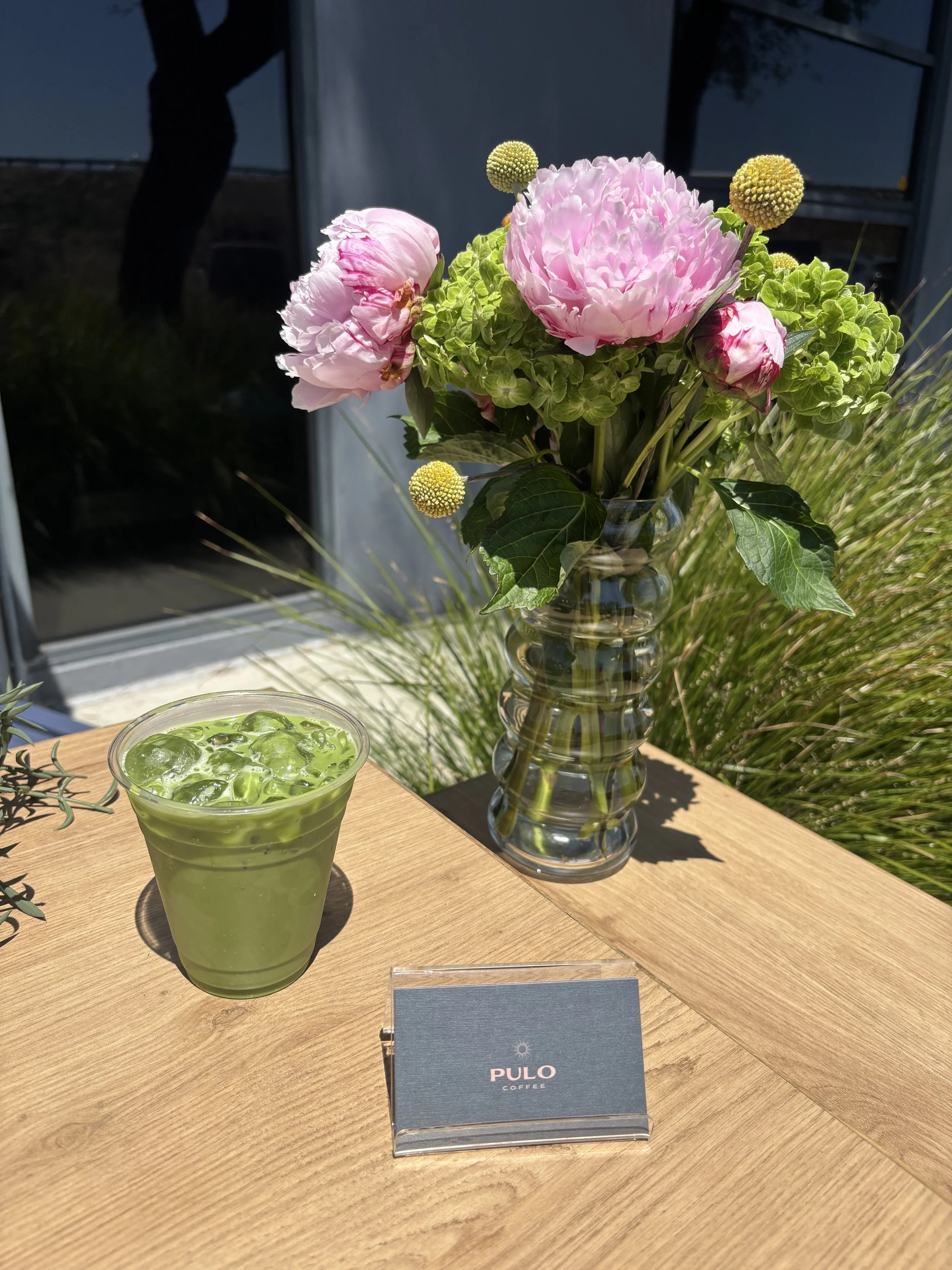 Pulo Coffee iced matcha latte with fresh flowers at outdoor matcha bar catering event in Los Angeles