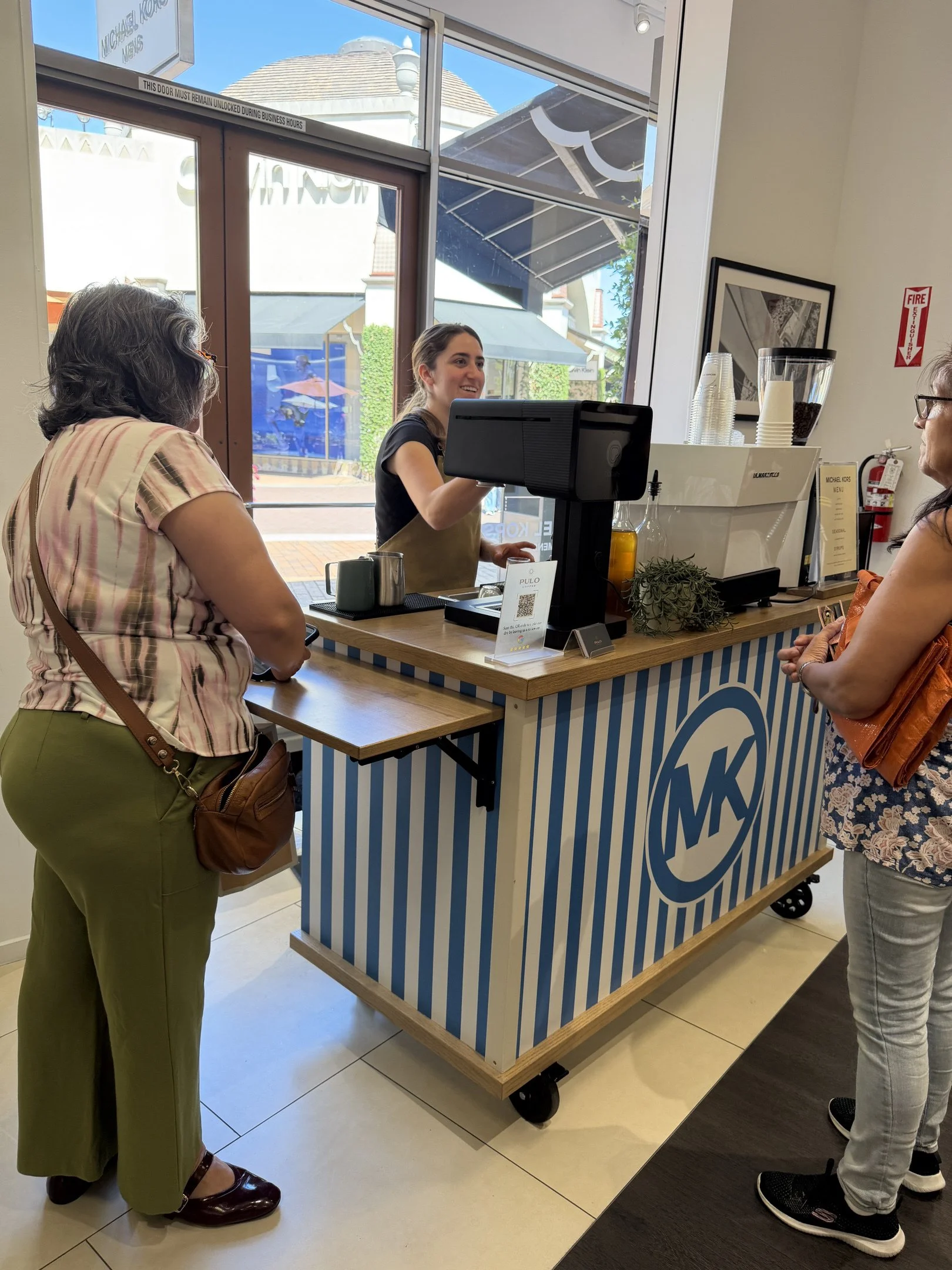 Pulo Coffee barista serving guests at Michael Kors branded coffee cart at Los Angeles retail brand activation