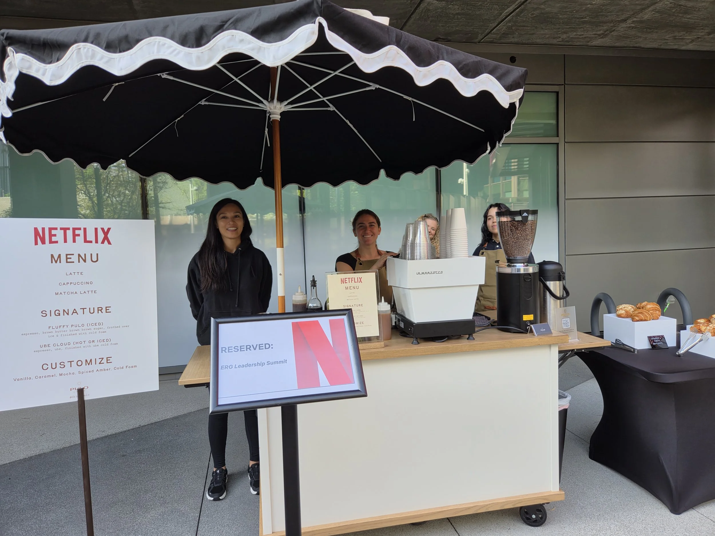 Pulo Coffee baristas at Netflix ERG Leadership Summit with branded menu and La Marzocco espresso bar