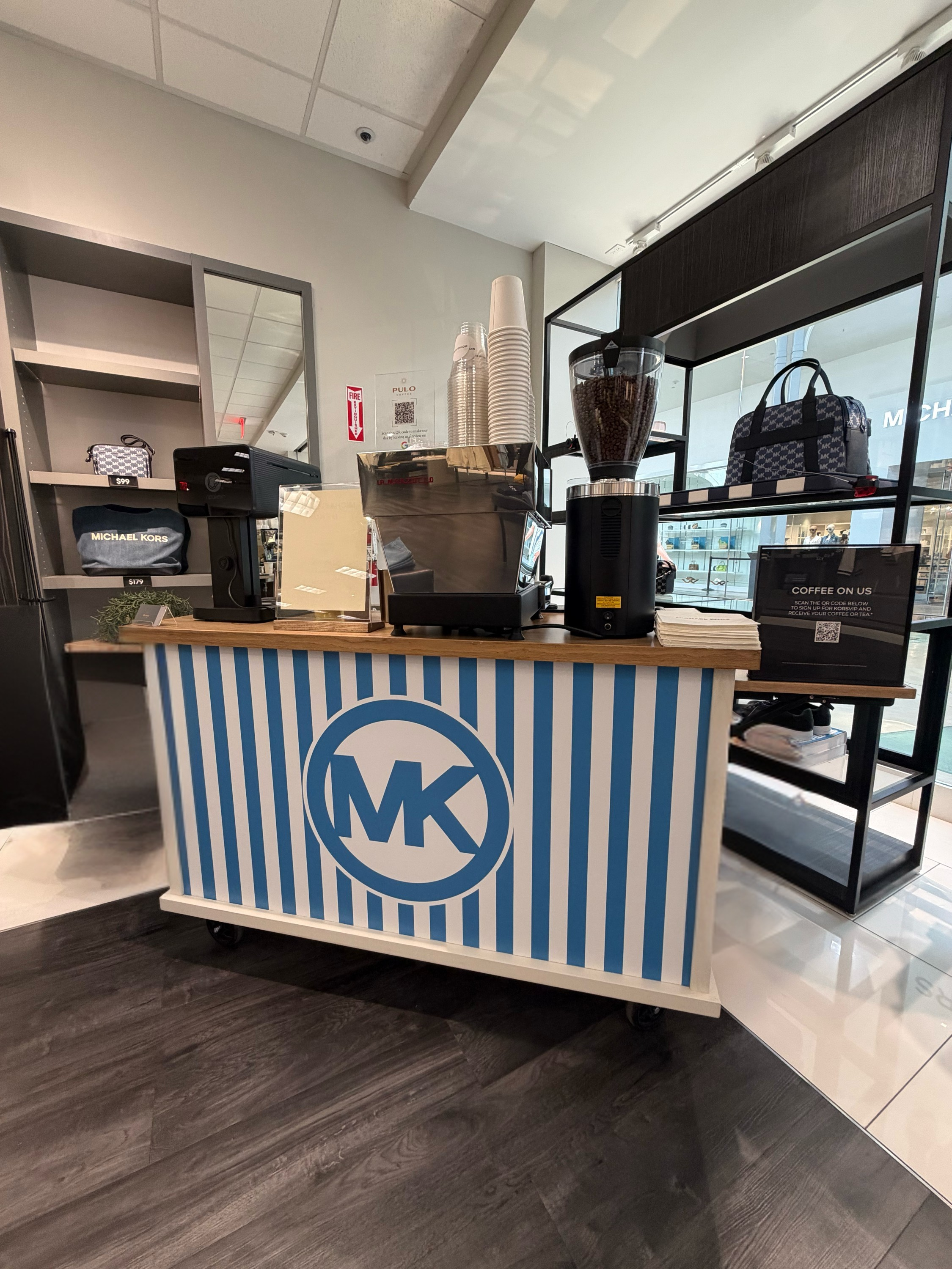 Pulo Coffee branded coffee cart with Michael Kors MK logo wrap at a retail brand activation in Los Angeles