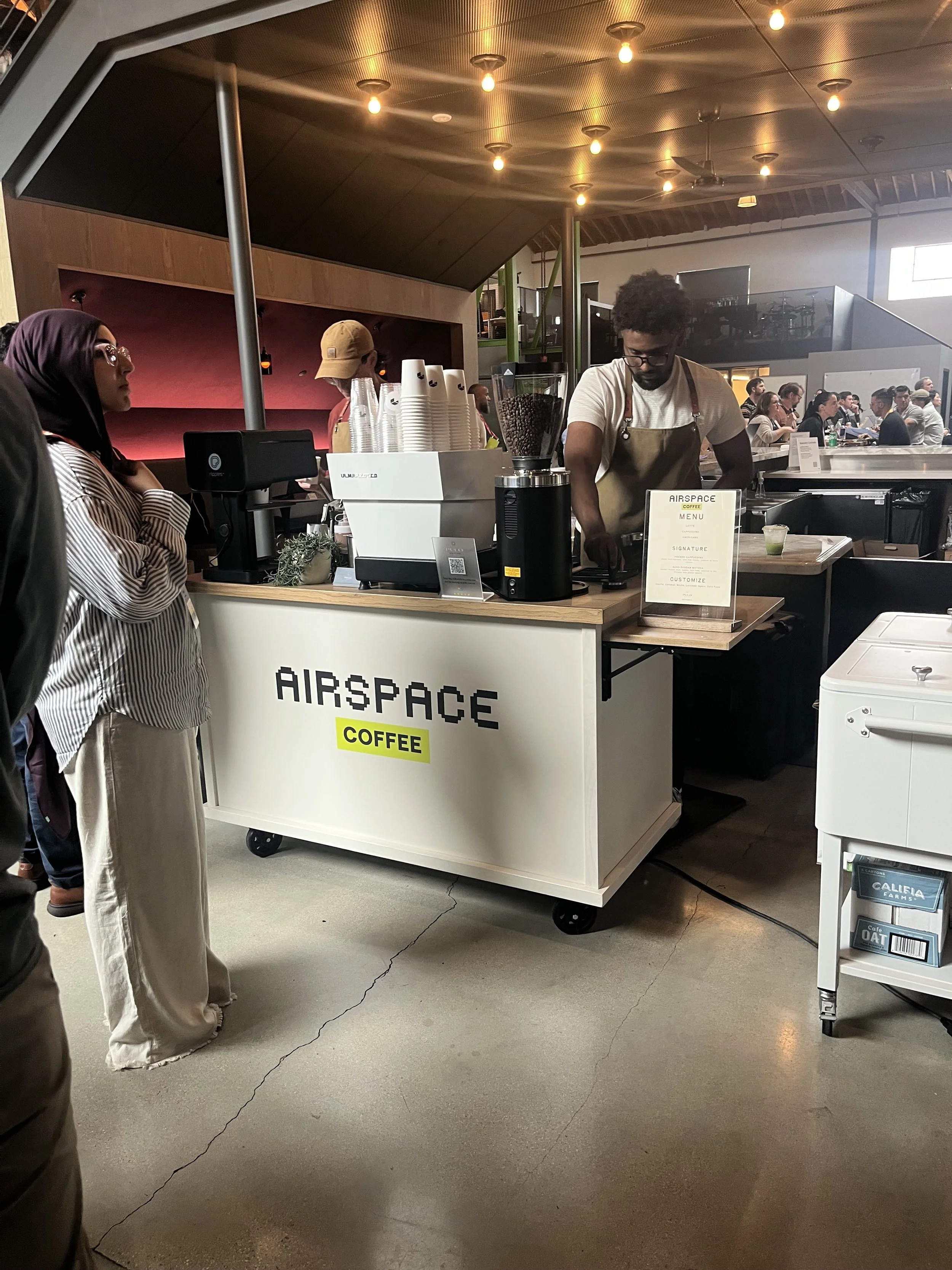 Pulo Coffee barista serving guest at custom-branded corporate coffee cart inside Los Angeles event venue