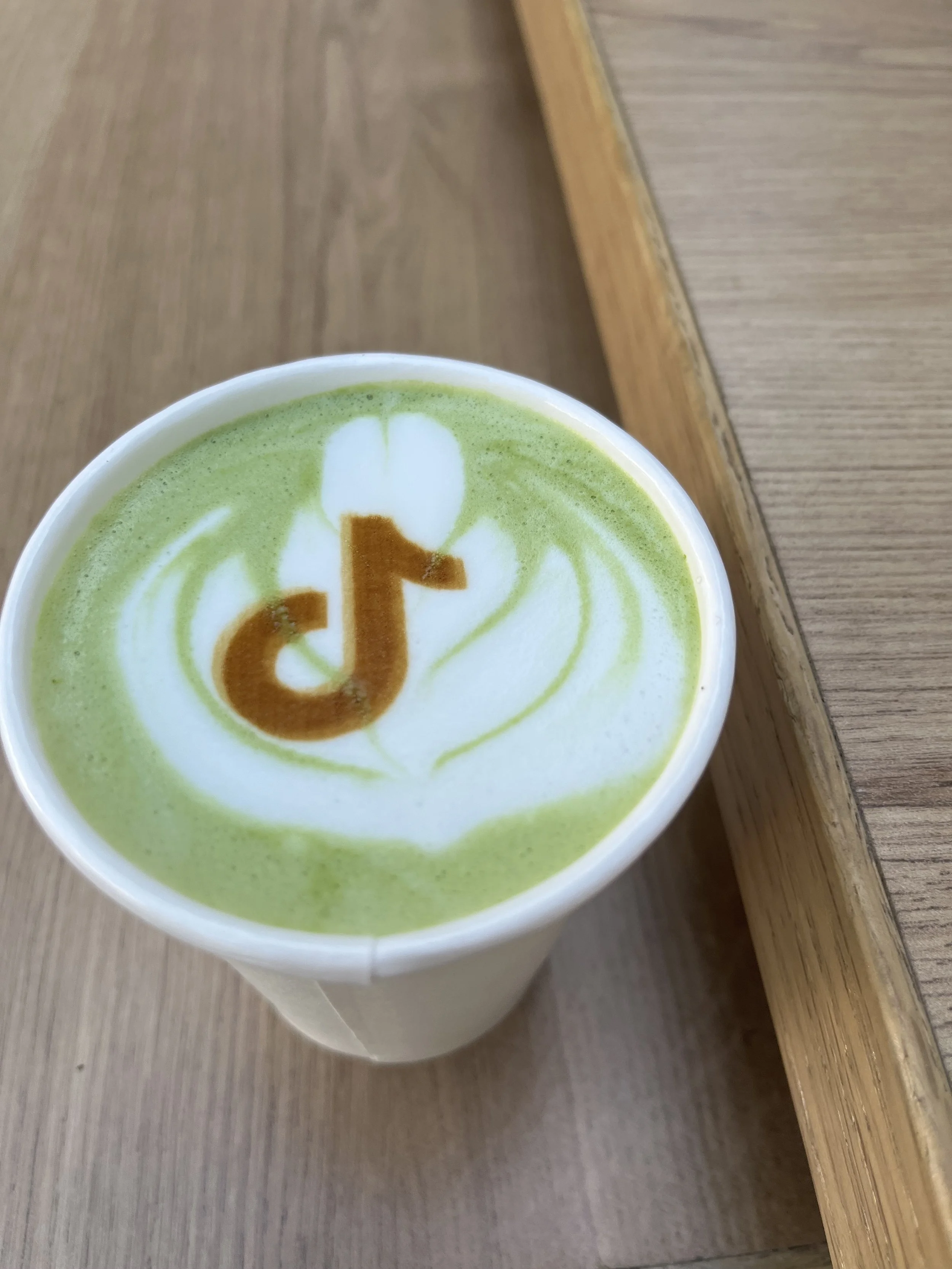 Matcha latte with custom TikTok logo art served by Pulo Coffee at a brand activation event in Los Angeles