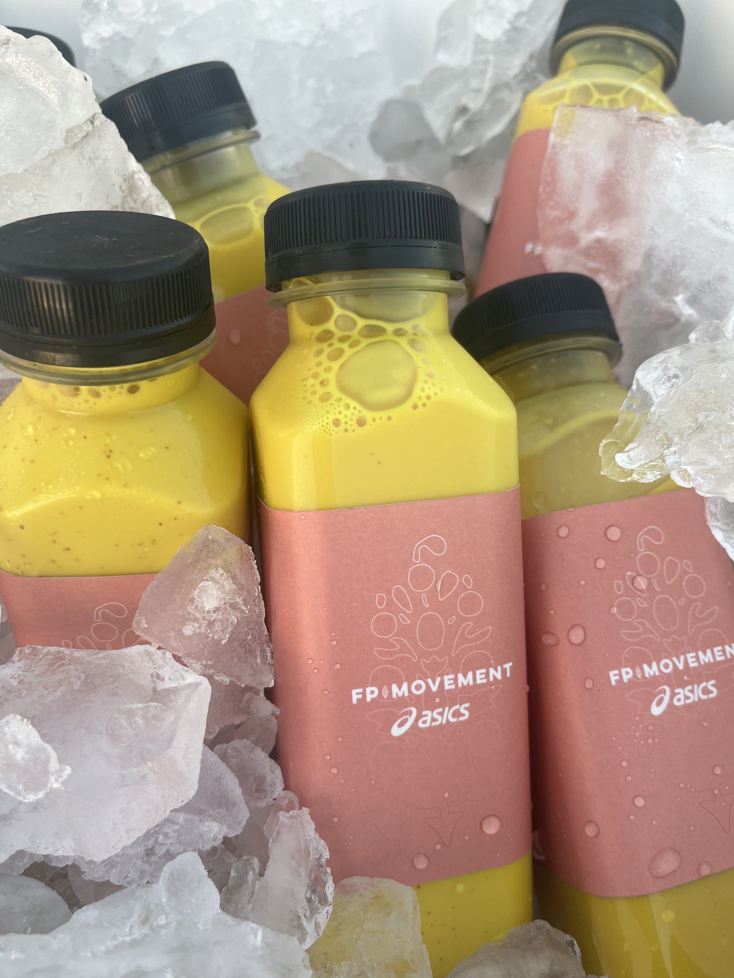 Custom branded FP Movement x Asics golden turmeric bottled lattes on ice by Pulo Coffee for outdoor brand activation in Los Angeles
