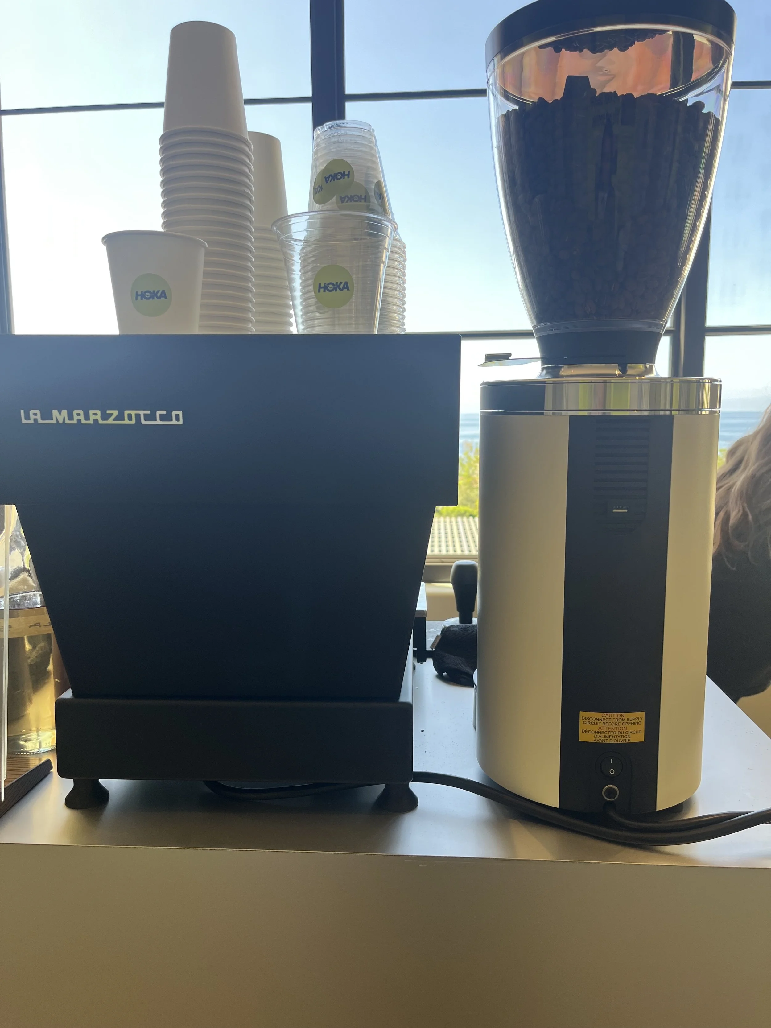 Custom branded Hoka cups and La Marzocco espresso machine at a multi-day corporate conference coffee cart by Pulo Coffee