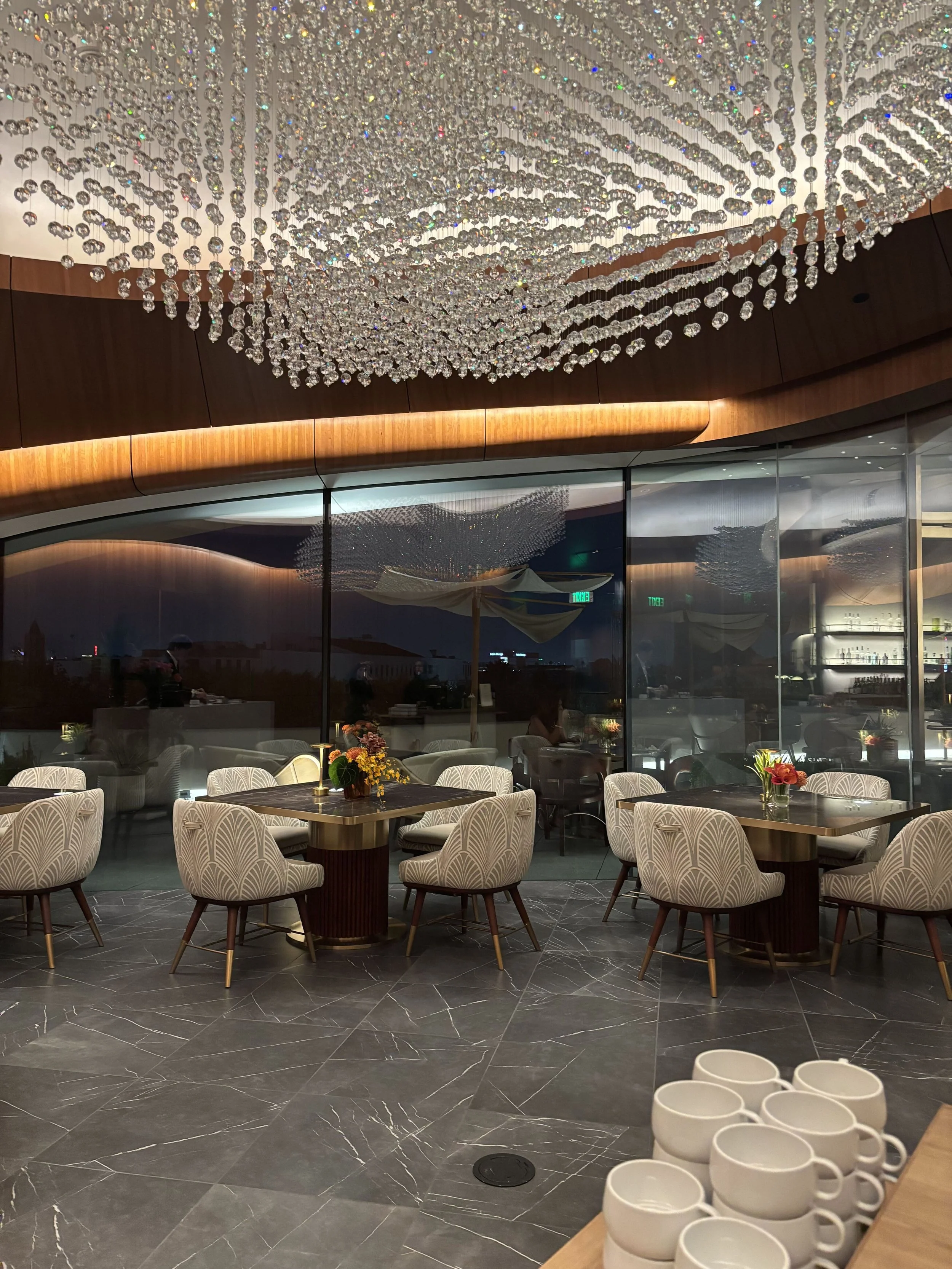 Skywalker Grill interior at the Lucas Museum of Narrative Art opening gala in Los Angeles with crystal chandelier and evening city view
