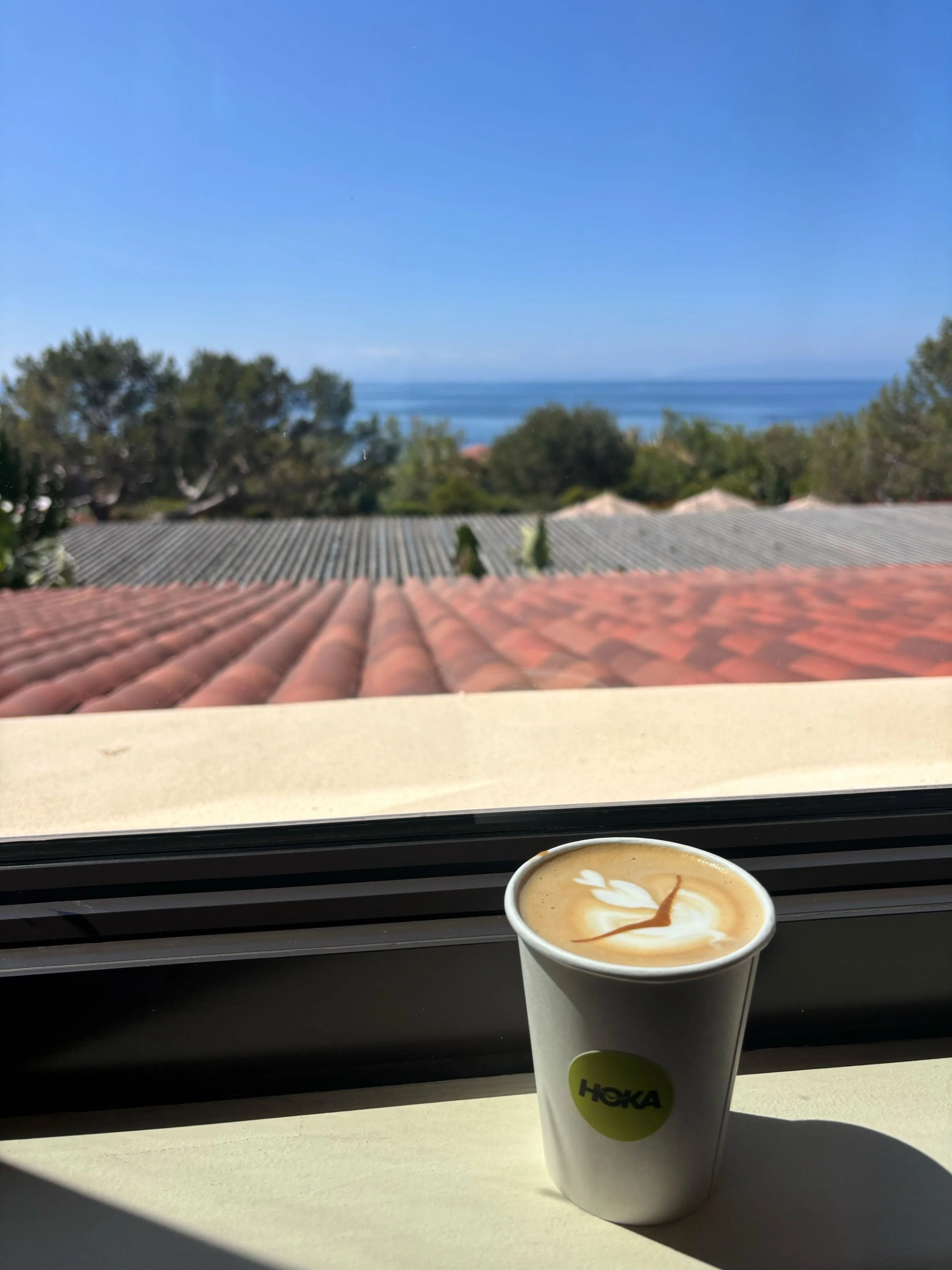 Branded Hoka coffee cup with latte art at a five-day global brand conference coffee catering setup in Los Angeles