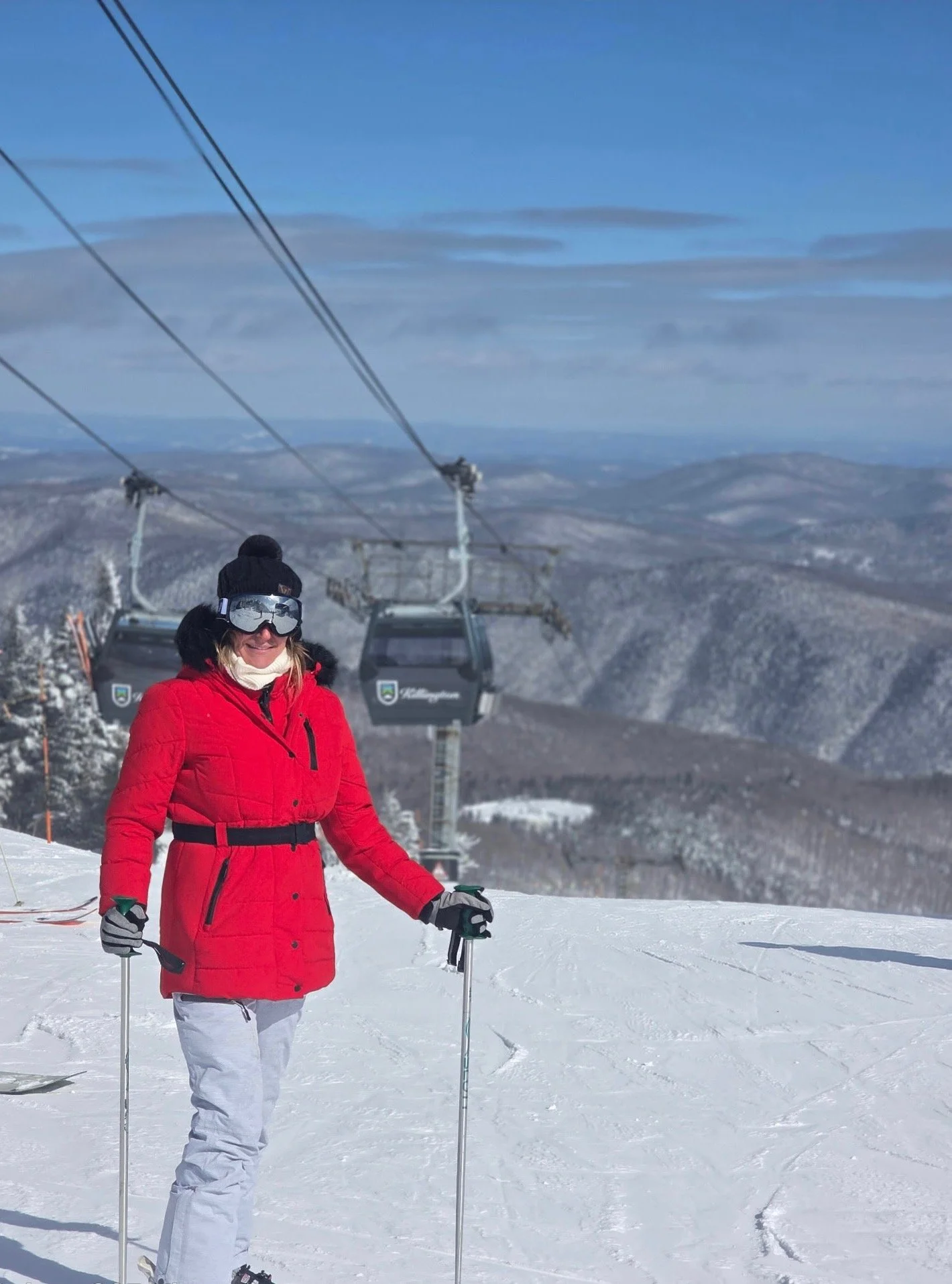 Skier in red jacket and goggles on snowy  mountain posing for picture, proving success after seeing Dr. Zach Kaplan