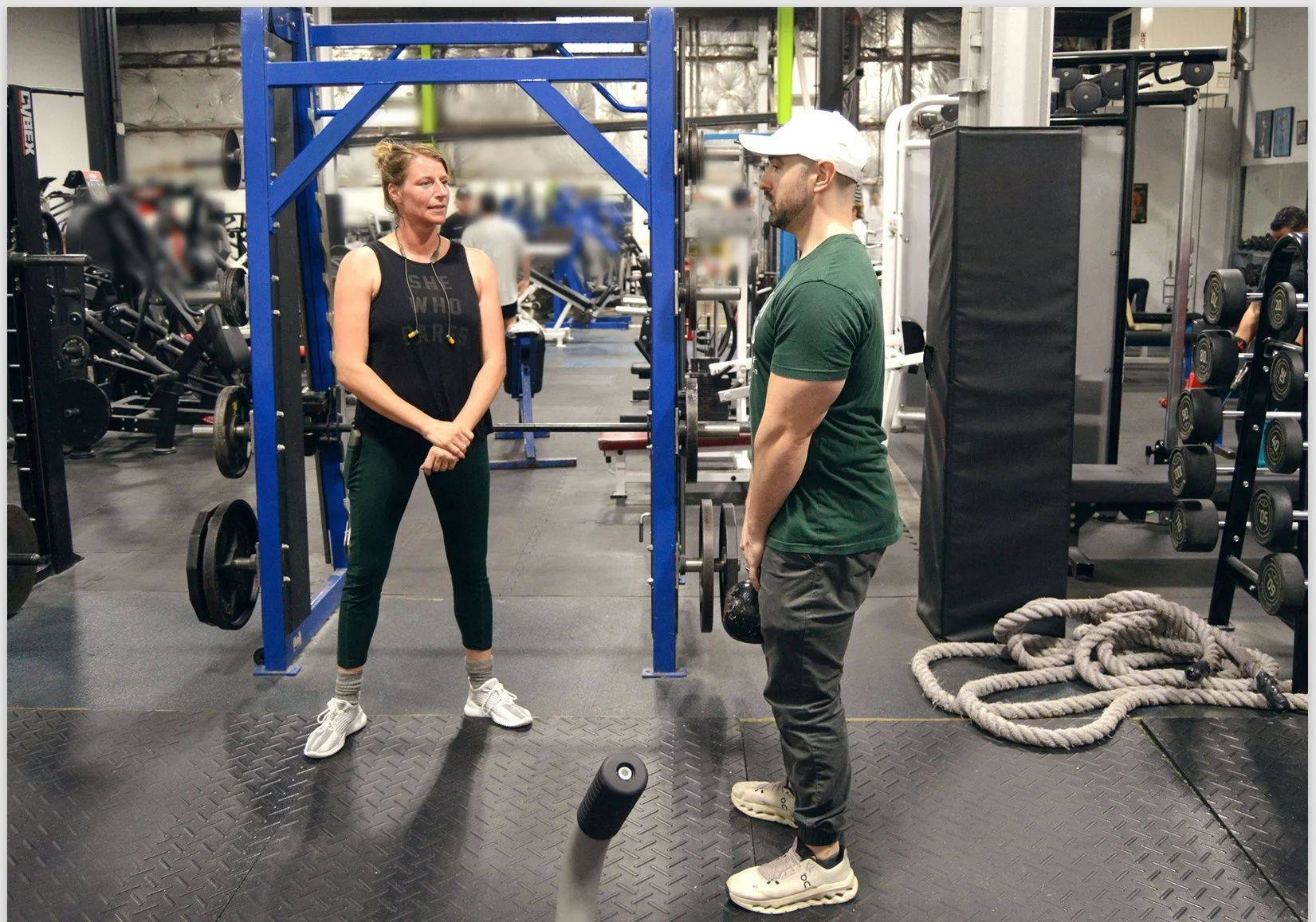 Dr. Zach Kaplan demonstrating weight exercise to patient who is paying close attention in a gym setting